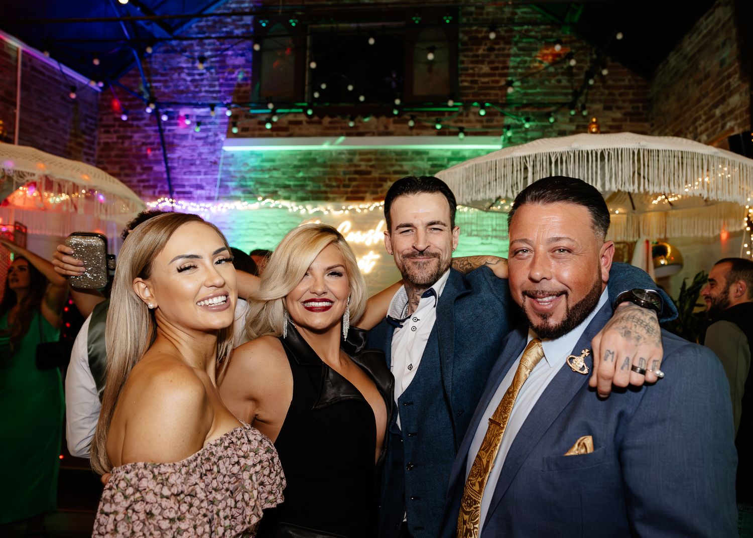Wedding reception dance party with colorful lighting and festive atmosphere.