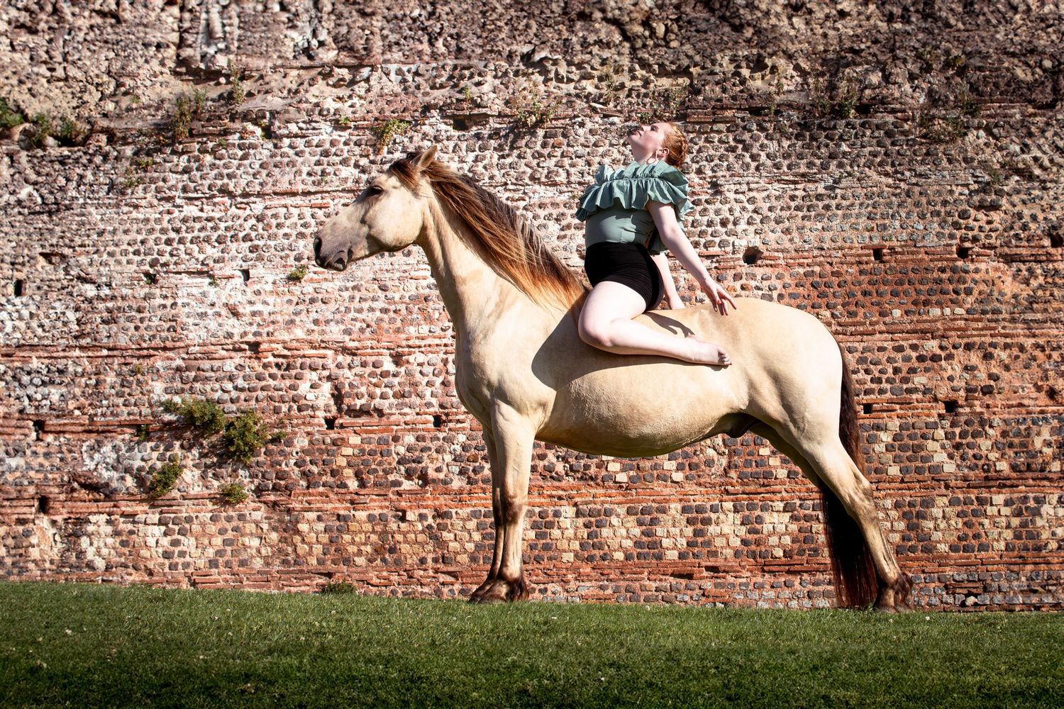 Photo portrait femme assise sur cheval. Wenaewe photographie sarthe photographe animalier. Pose équestre devant un mur gallo-romain Le Mans.