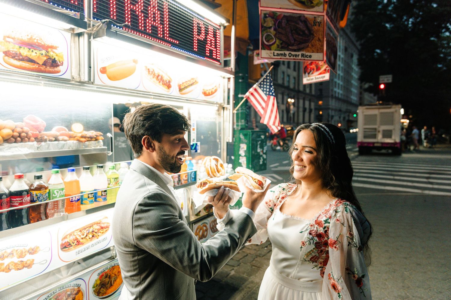 Newlyweds share hot dogs at a New York City street food cart on their wedding night.