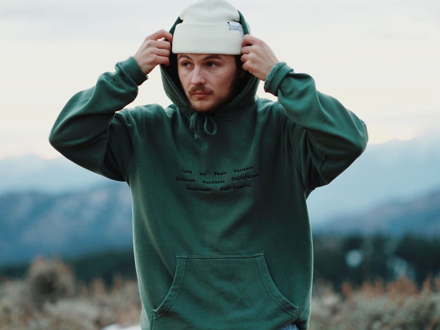 Elisha posing in front of the Entiat mountains for a clothing brand called Froot of the Spirit, representing his faith and fashion.
