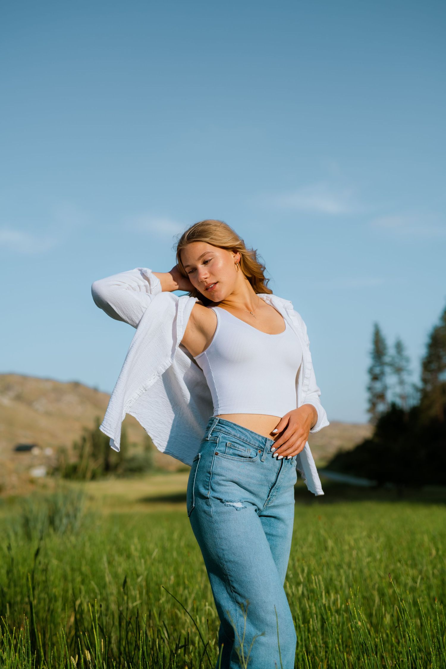Brewster High School senior walking through the valley grasses below the foothills in north-central Washington before the start of summer.