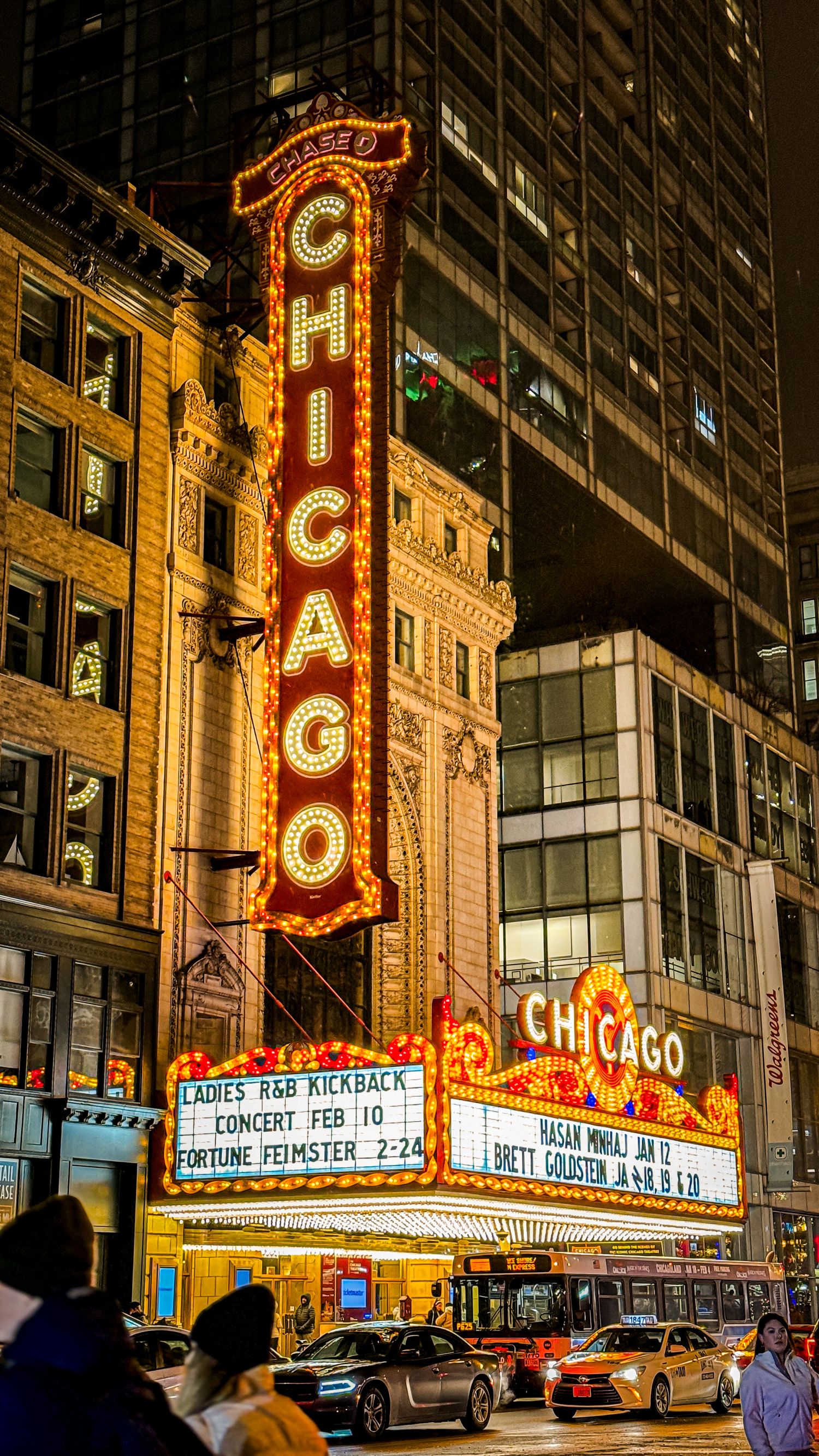 Historic Chicago Theatre's illuminated marquee at night with bright neon signage.