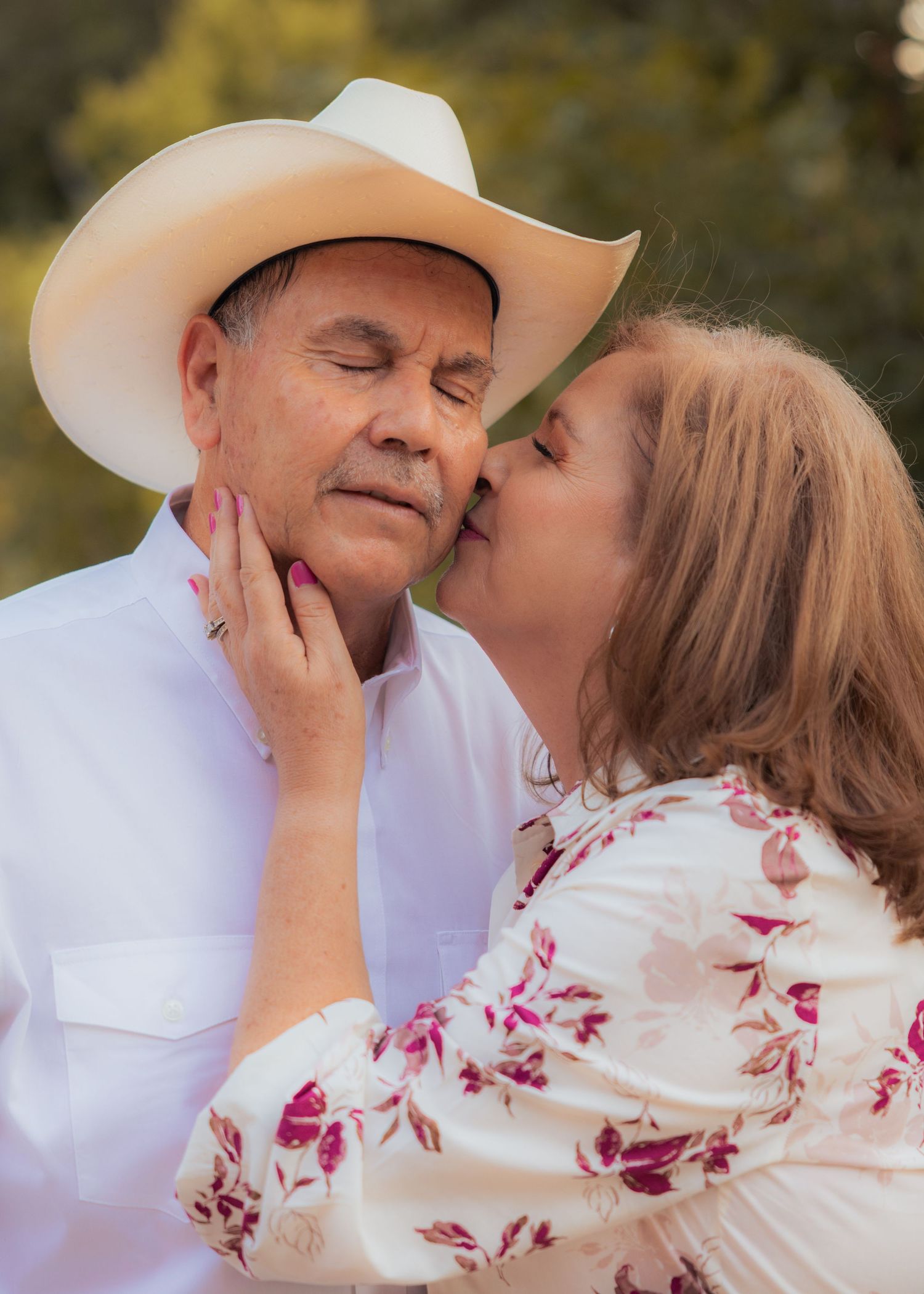 Intimate close-up shots of a couple sharing romantic moments in white and floral attire.