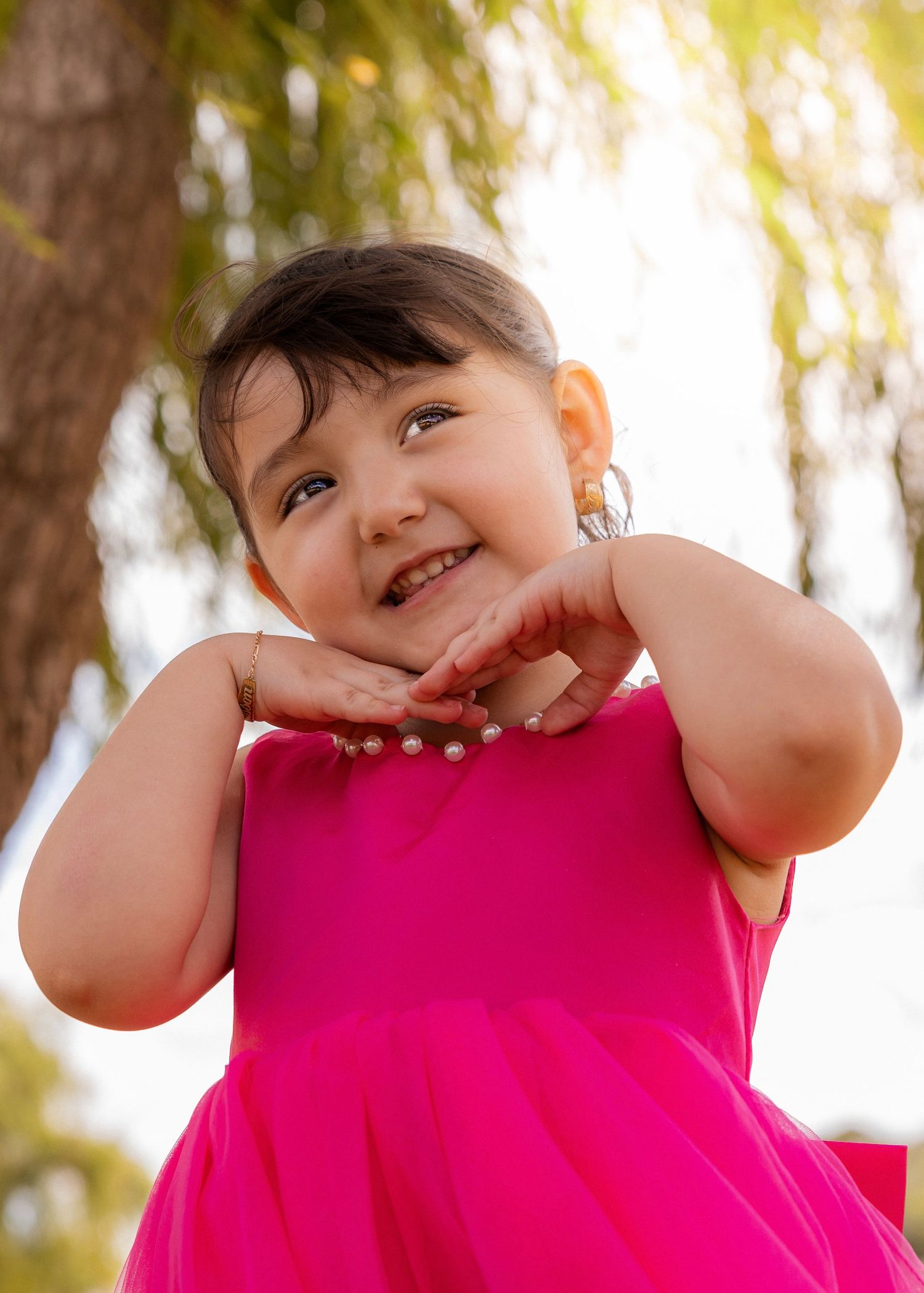 Child in bright pink top making playful expressions.