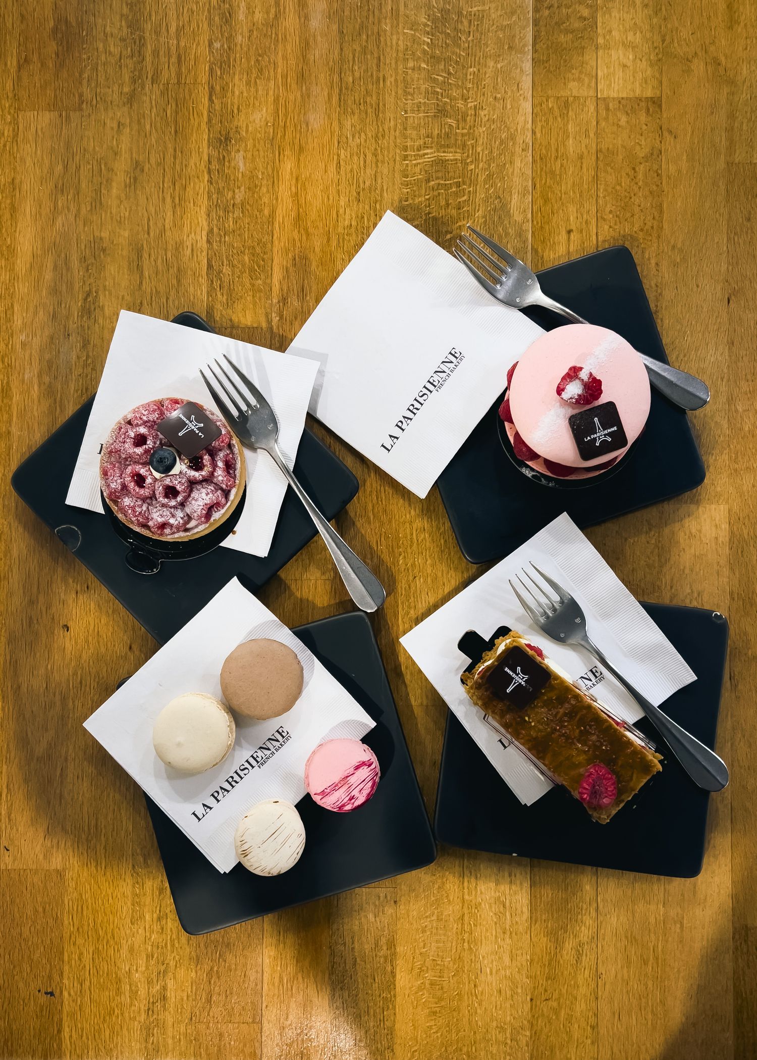 Overhead view of dessert plates arranged on a wooden table surface.