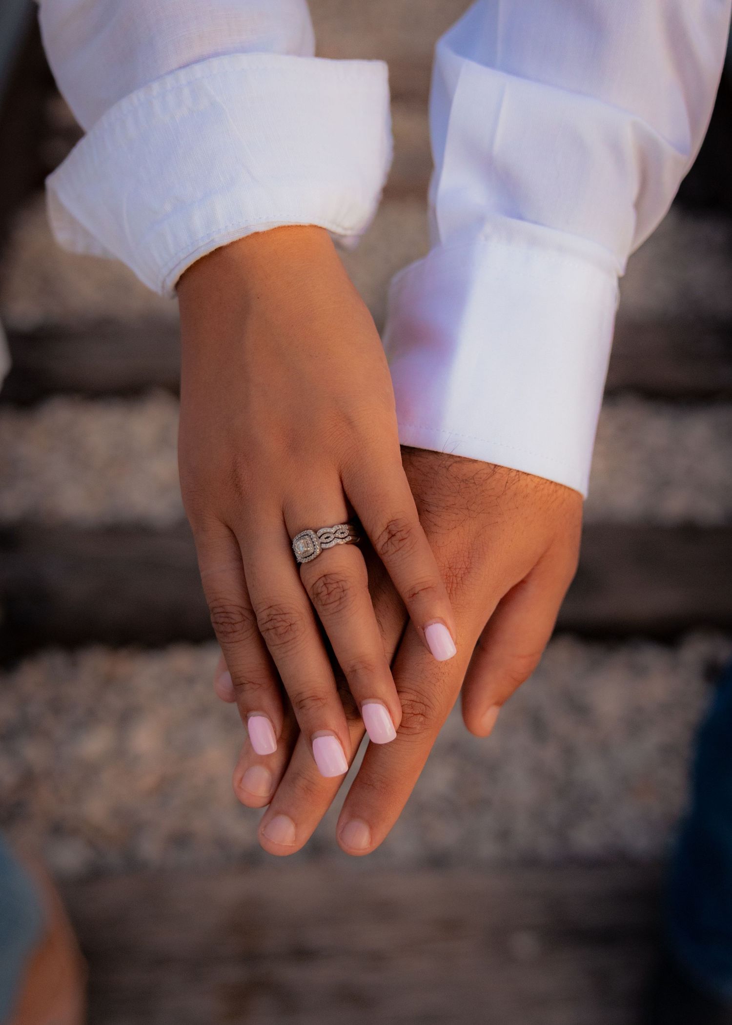 Close-up shots of hands showing engagement ring details in white attire.