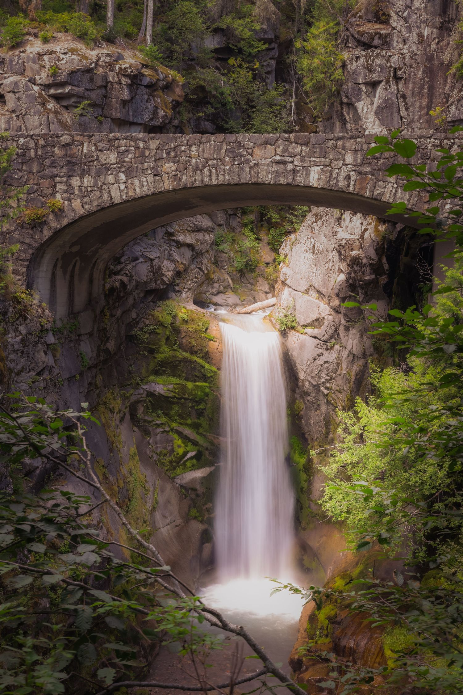 Christine Falls flows under a historic stone bridge at Mount Rainier National Park.