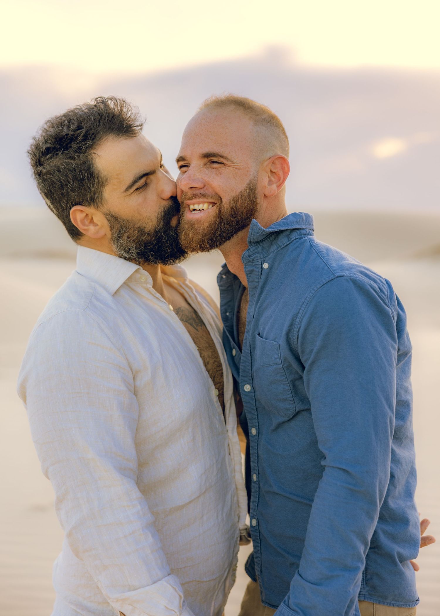 Romantic couple sharing intimate moments at sunset against beach backdrop.