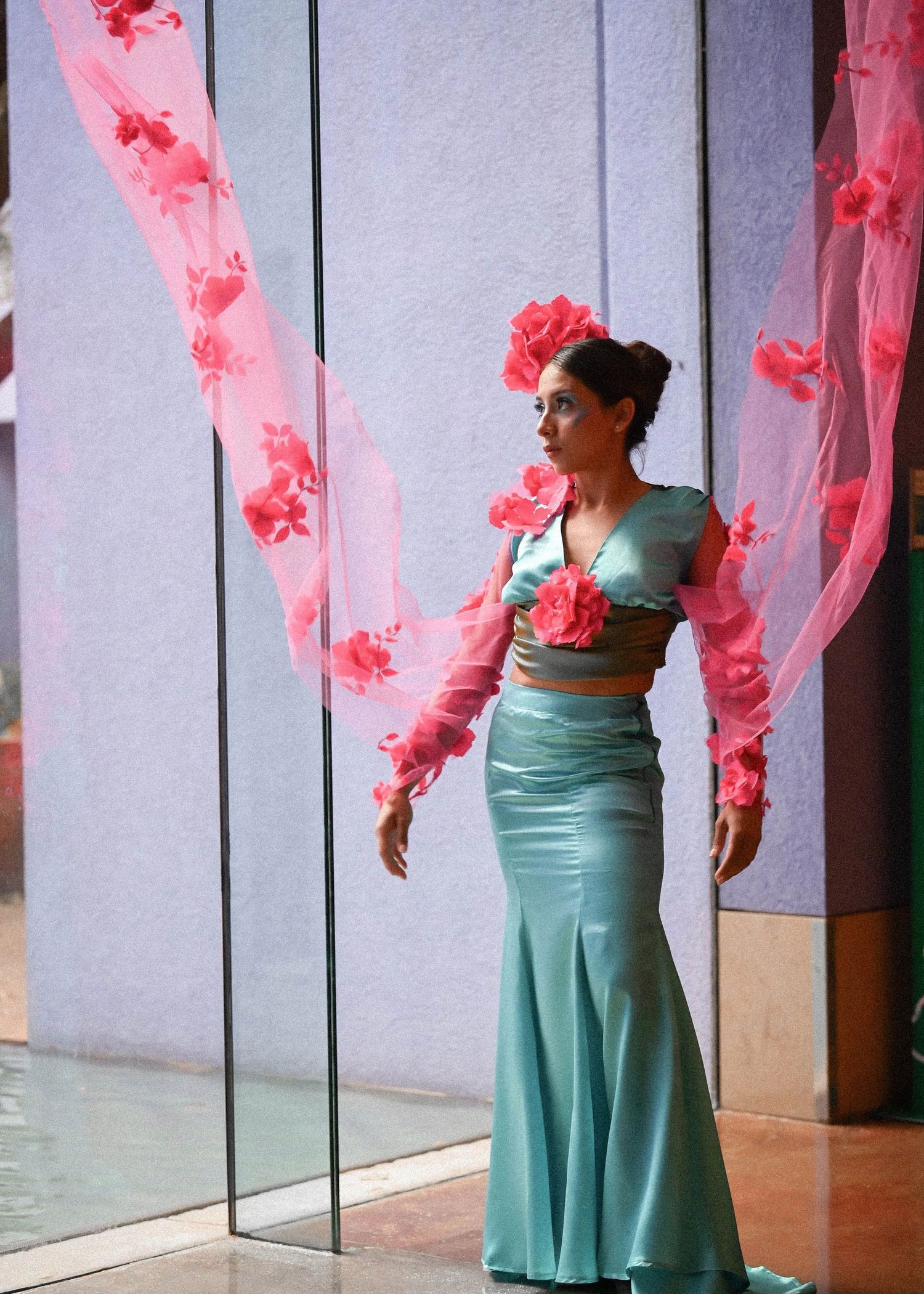 Fashion sequence showing teal dress with flowing pink fabric accents.