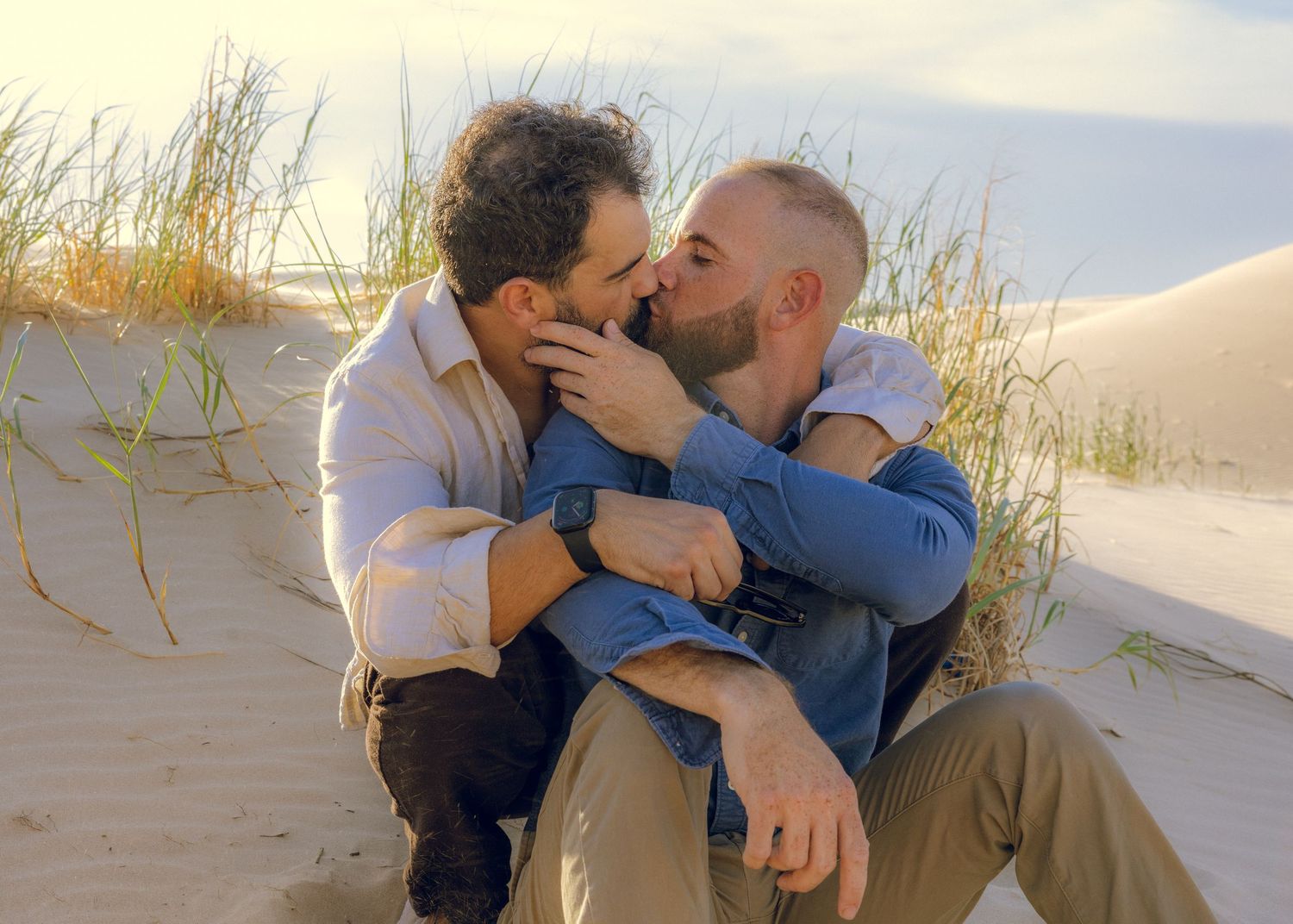 Romantic moment captured in sequence on sandy beach with grass.
