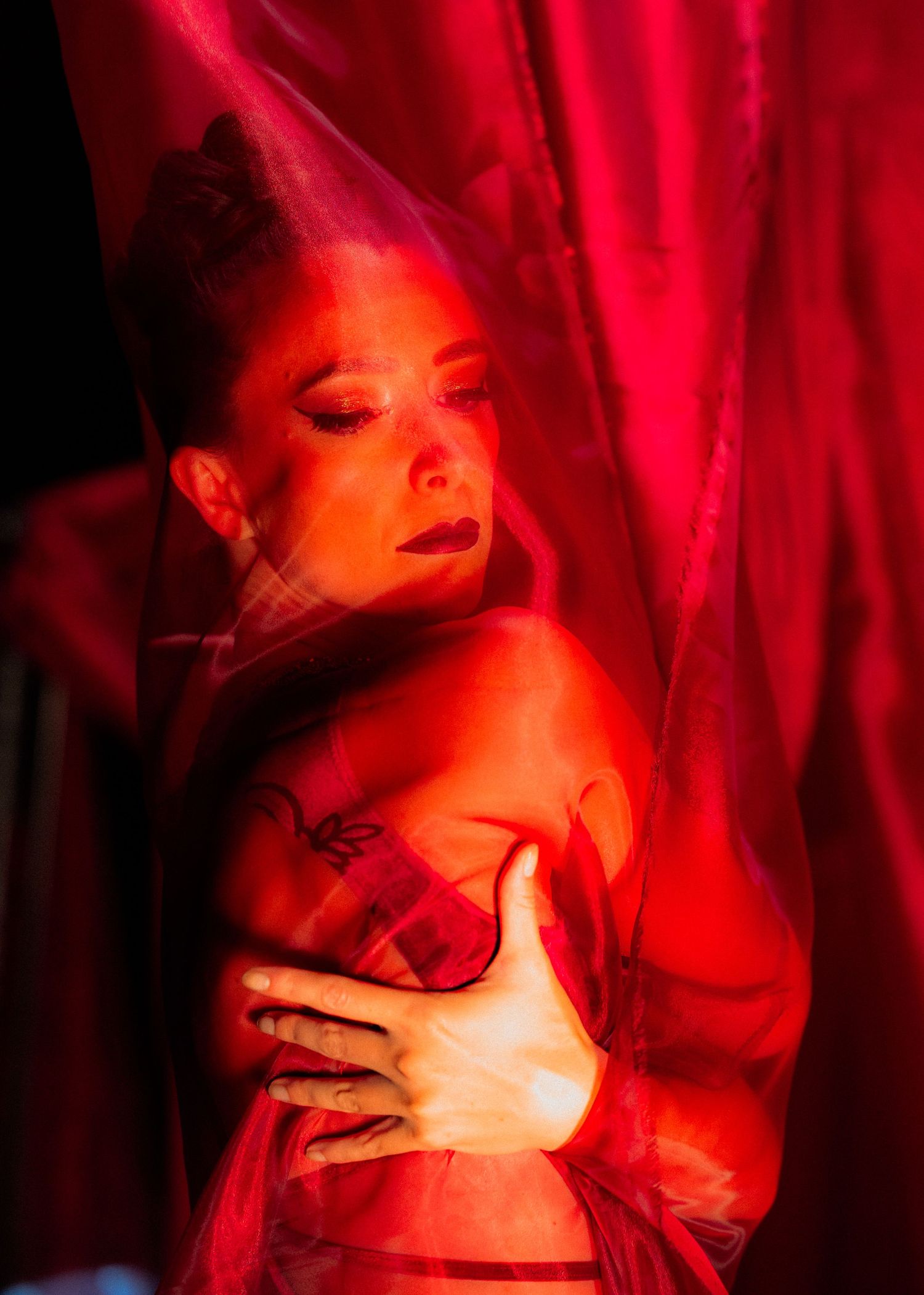 Moody portrait series bathed in deep red theatrical lighting.