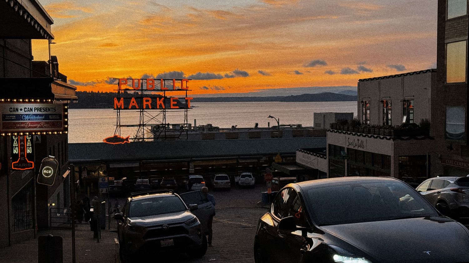 Panoramic view of cars parked along waterfront during sunset.