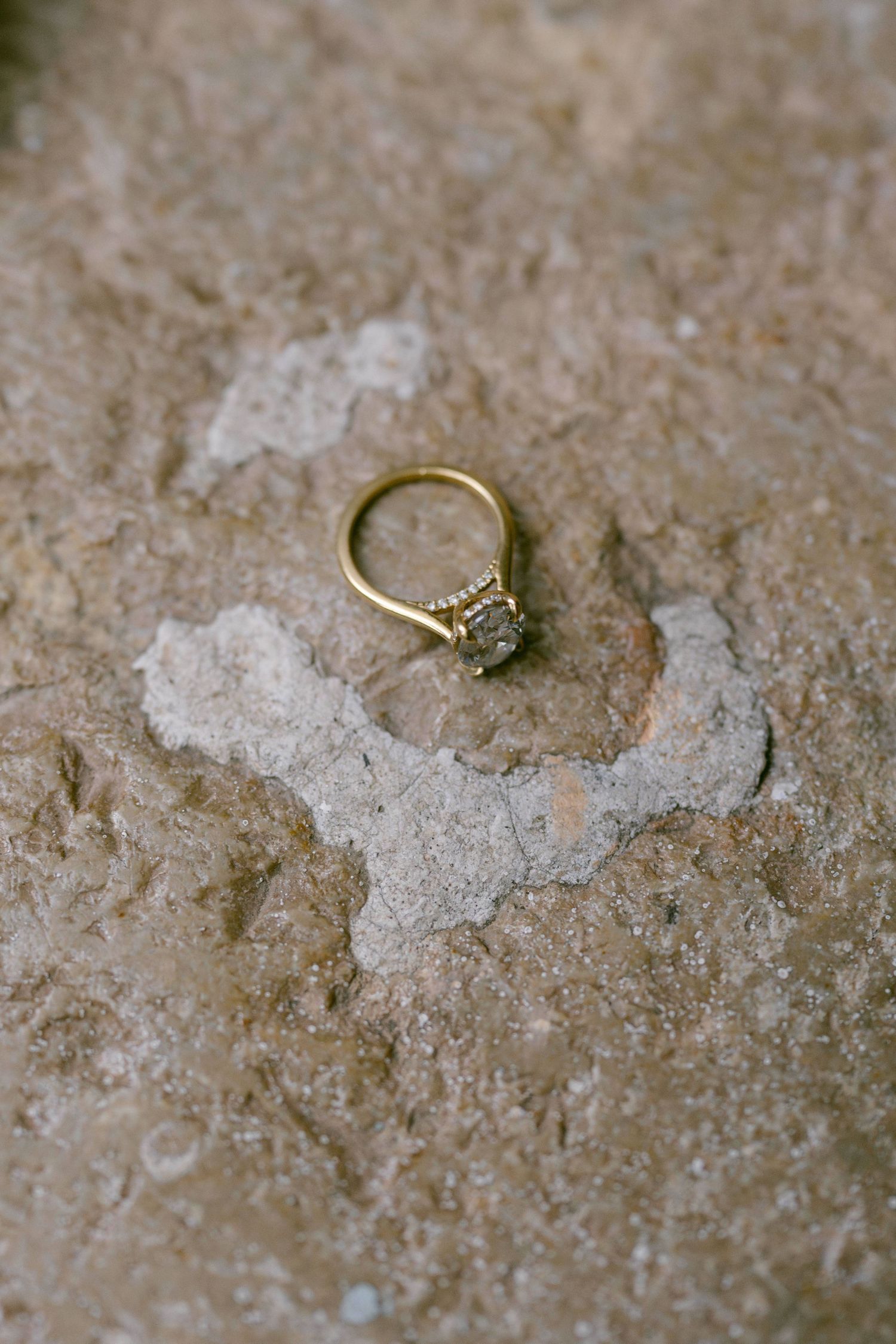 Wedding rings placed on textured surface during wedding day preparations