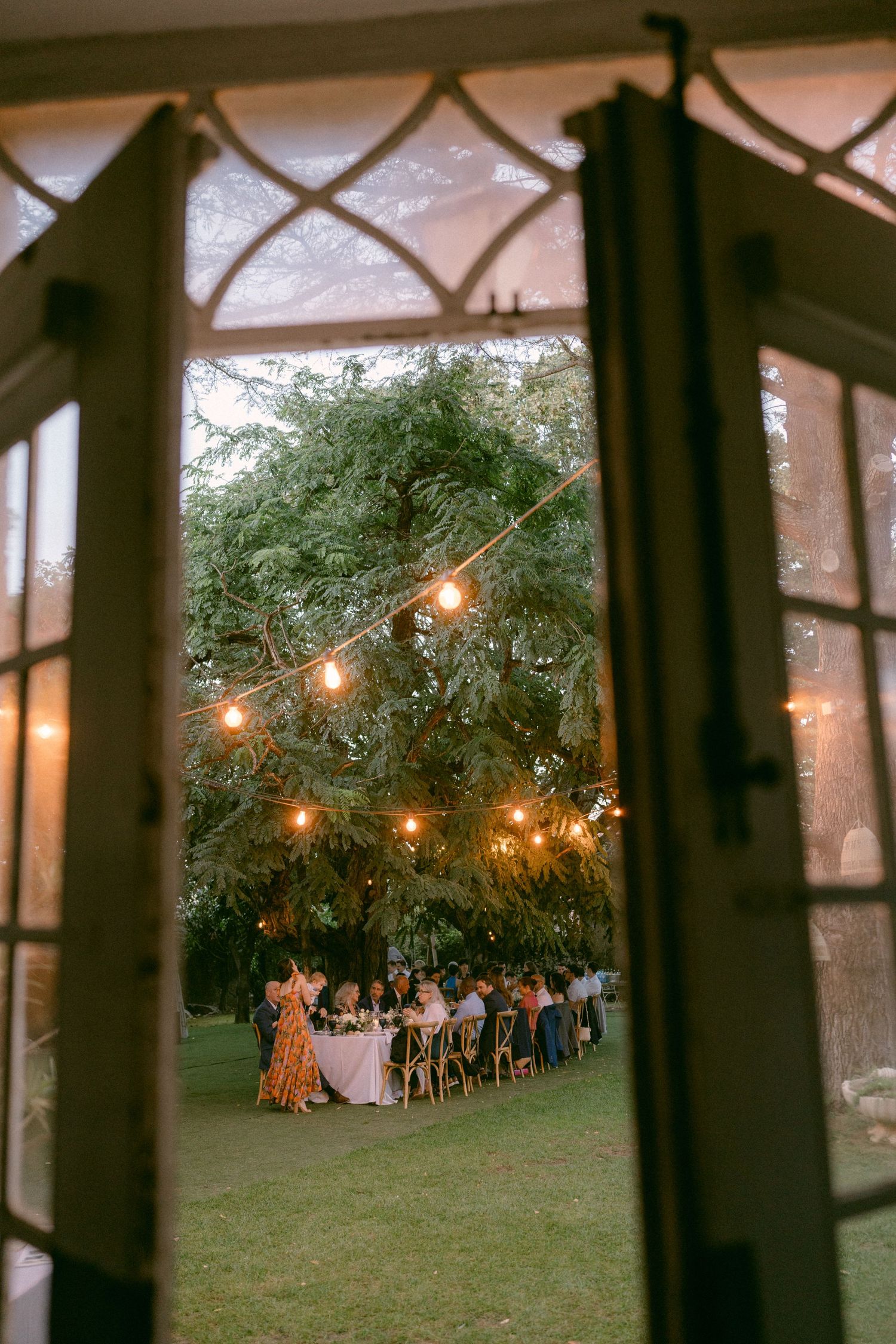 Wedding reception dinner seen through open doors at outdoor venue, in Lisbon Portugal
