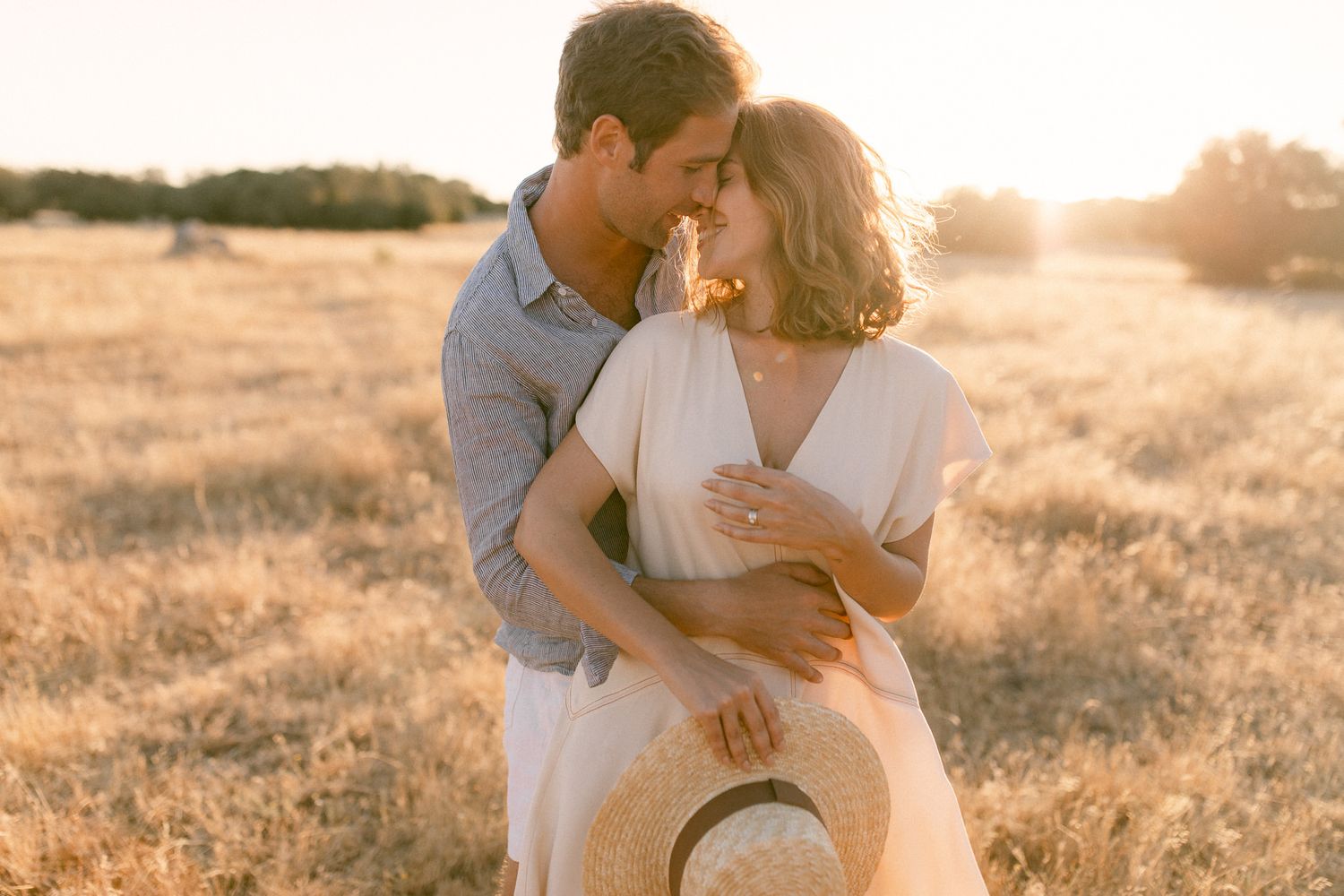 Bride and groom embracing in golden field during sunset wedding session, in Sao Lourenço do Barrocal, Portugal