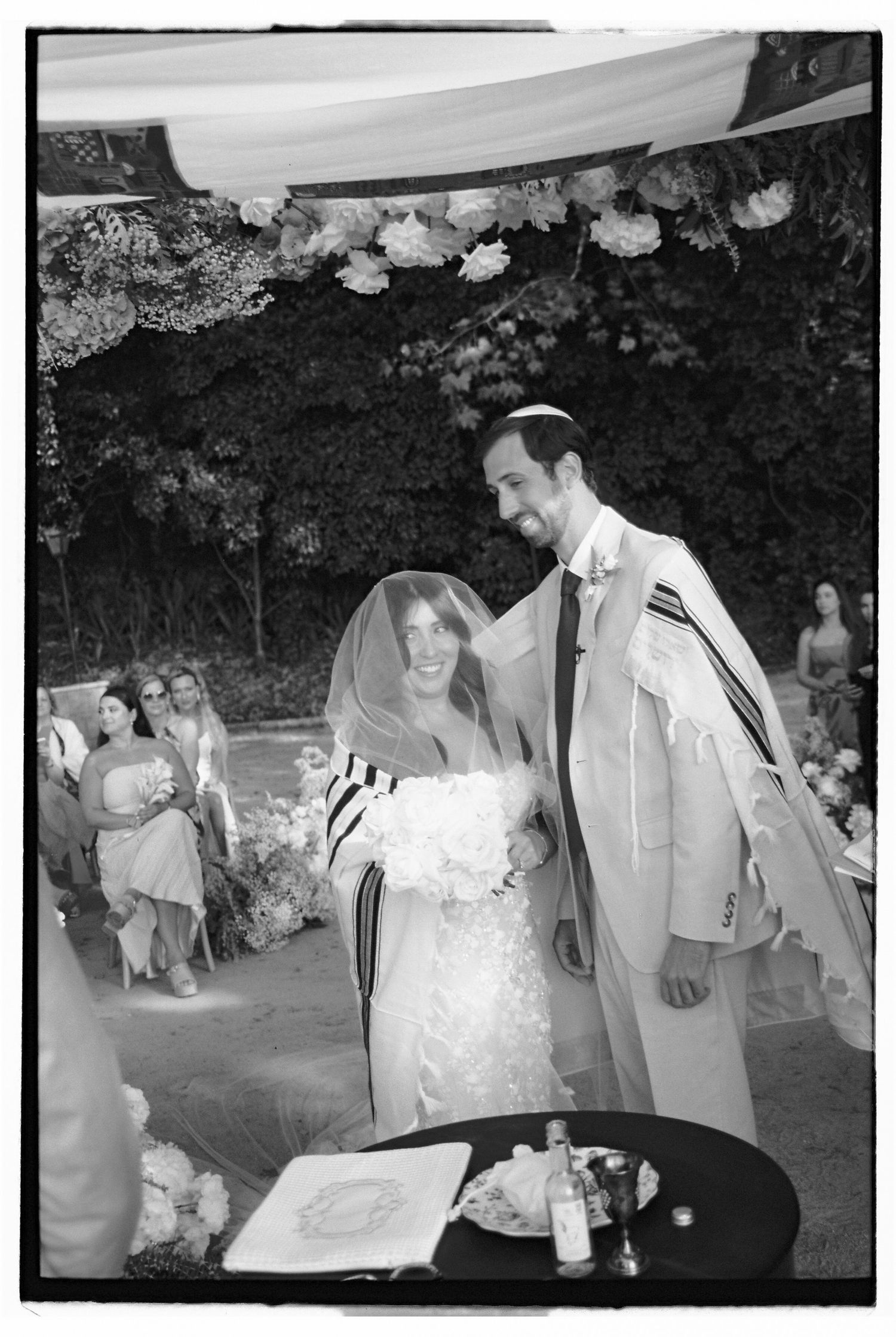 Jewish wedding ceremony with bride and groom smiling under the chuppah, groom wearing tallit, in Sintra, Portugal