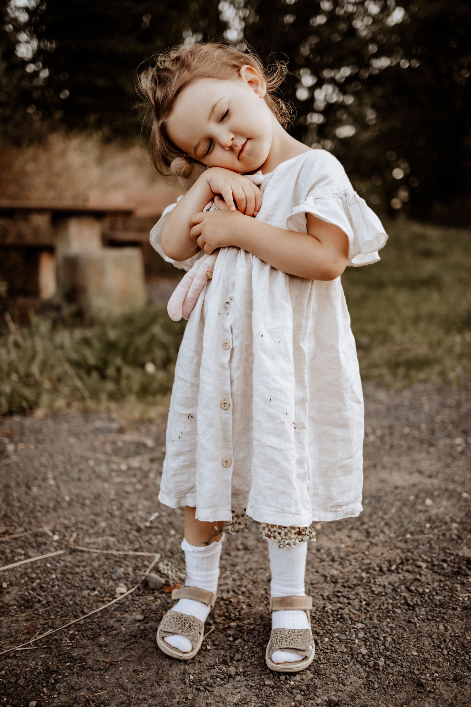 Mädchen kuschelt mit Puppe im Sommer