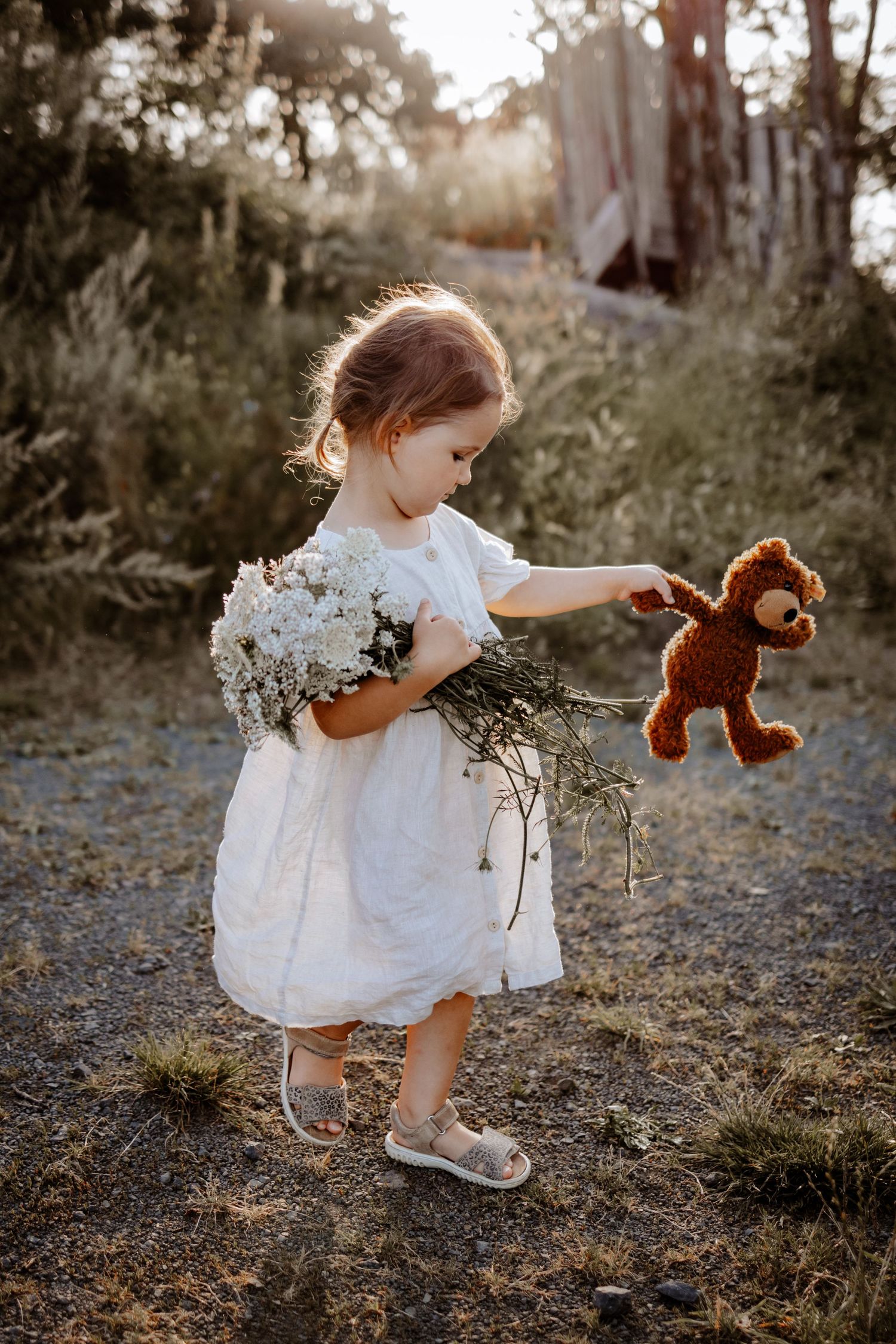 Mädchen mit Blumenstrauß und Teddybär