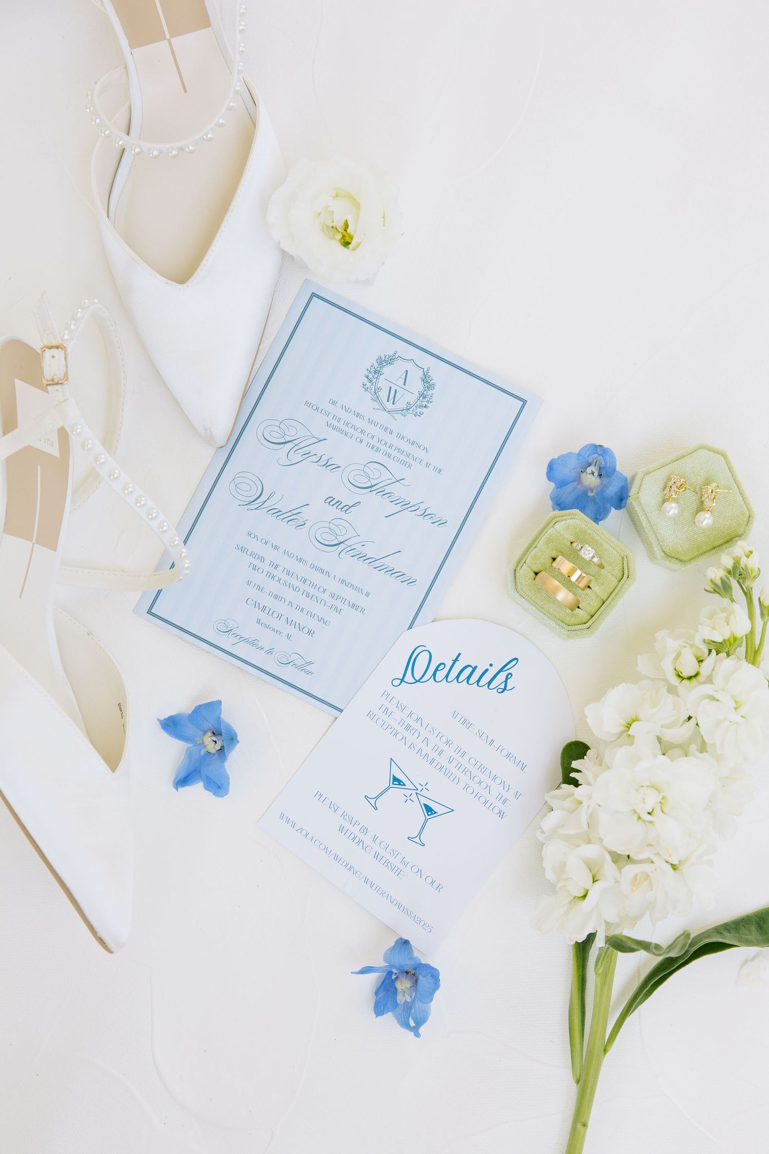 Elegant blue and white wedding invitation suite with delicate flowers and white bridal shoes.