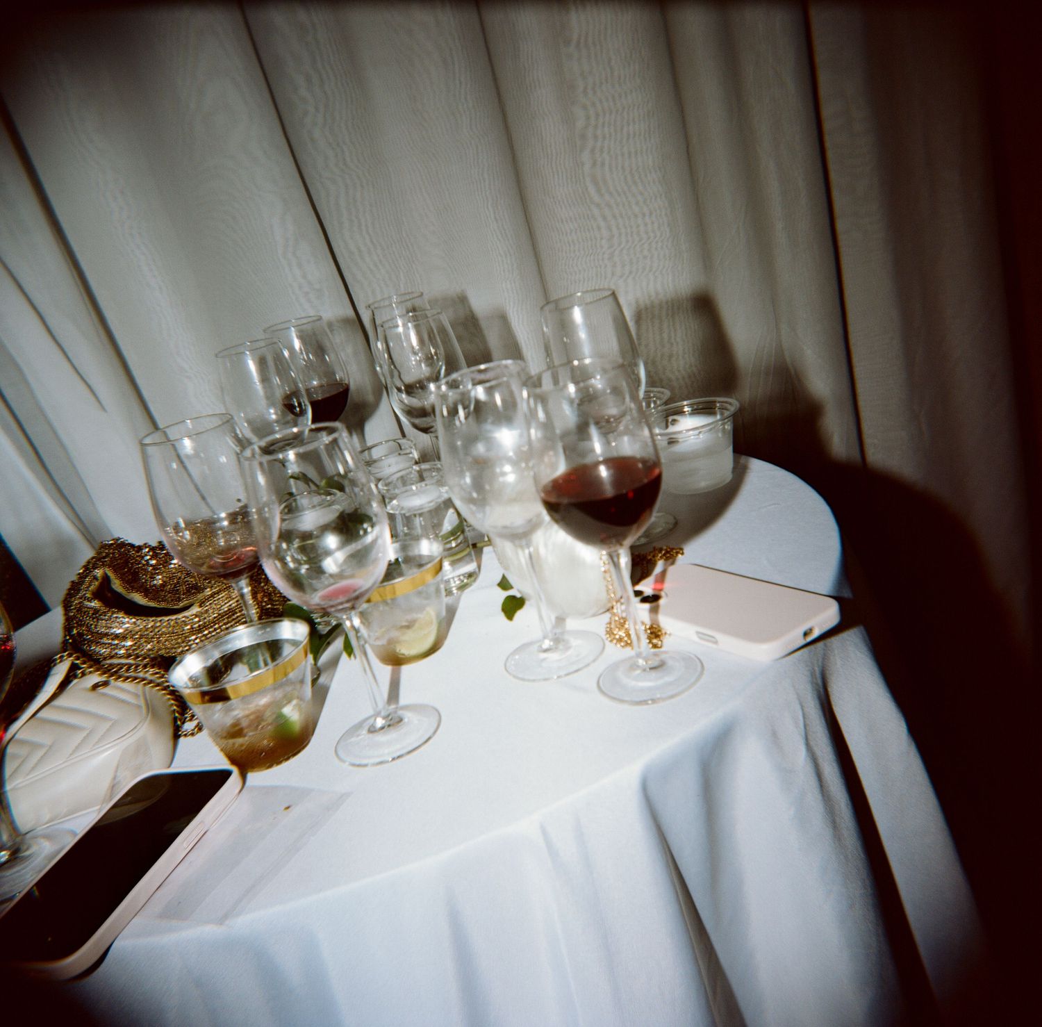 Assorted wine and water glasses arranged on white tablecloth at elegant wedding reception table.