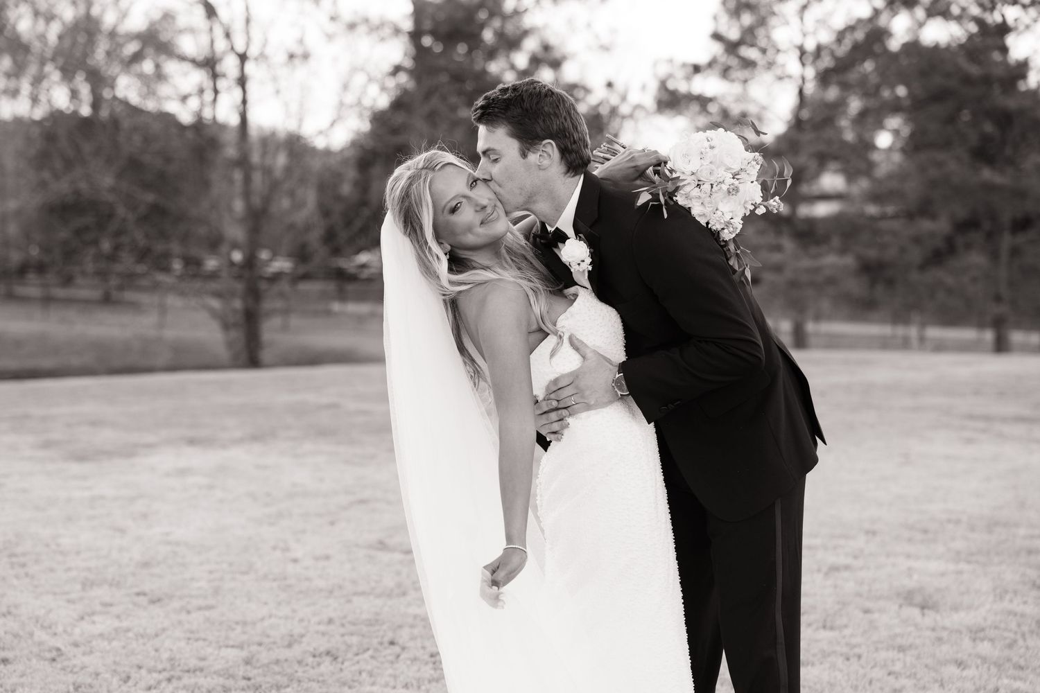 Romantic black and white wedding portraits taken in an outdoor garden setting.