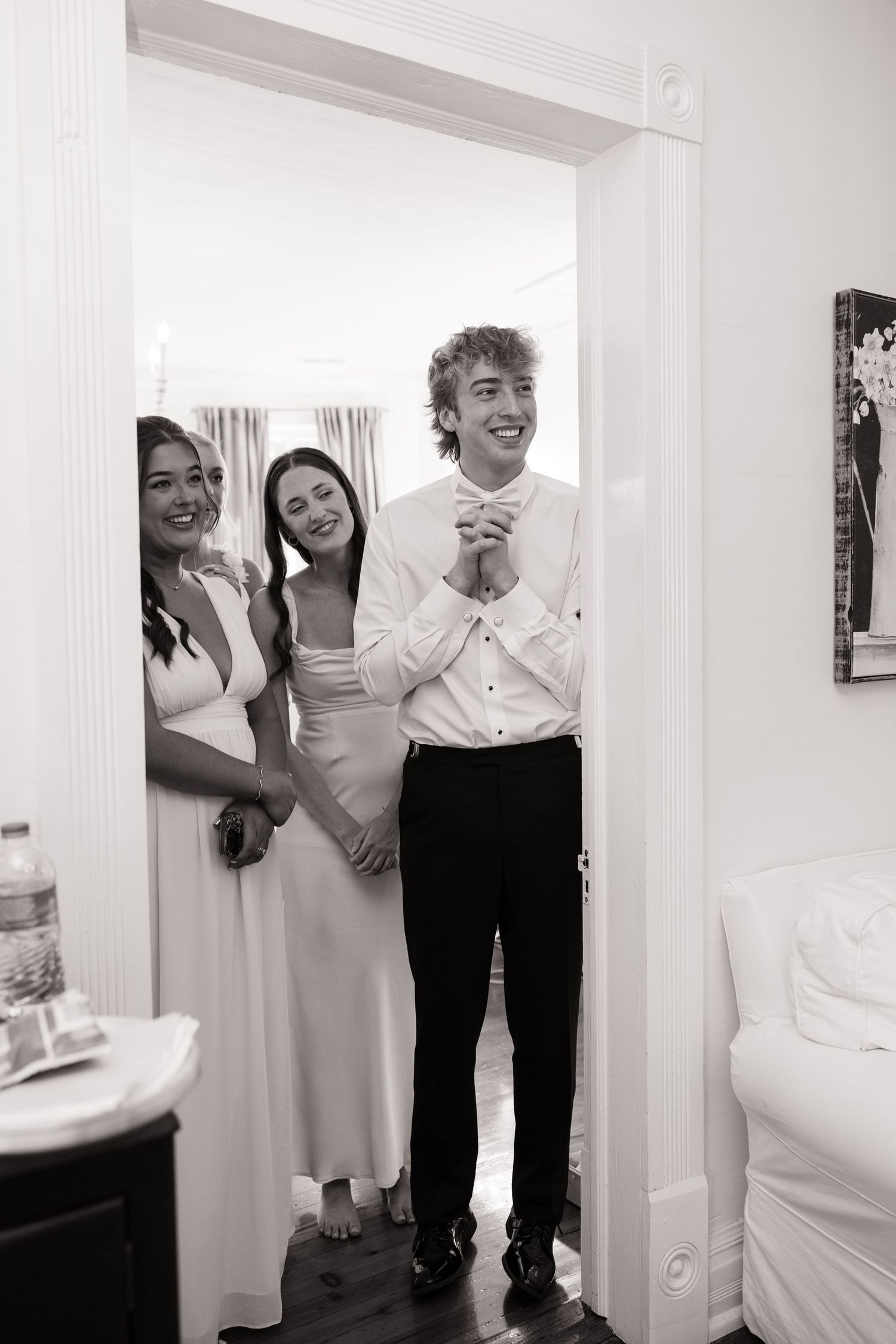 Black and white candid shots show joyful laughter and embraces during wedding preparations.