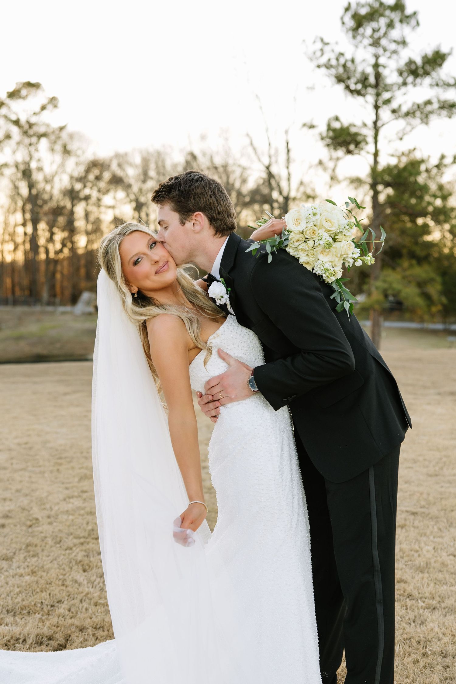 Playful portrait of couple sharing romantic moment with bouquet outdoors.
