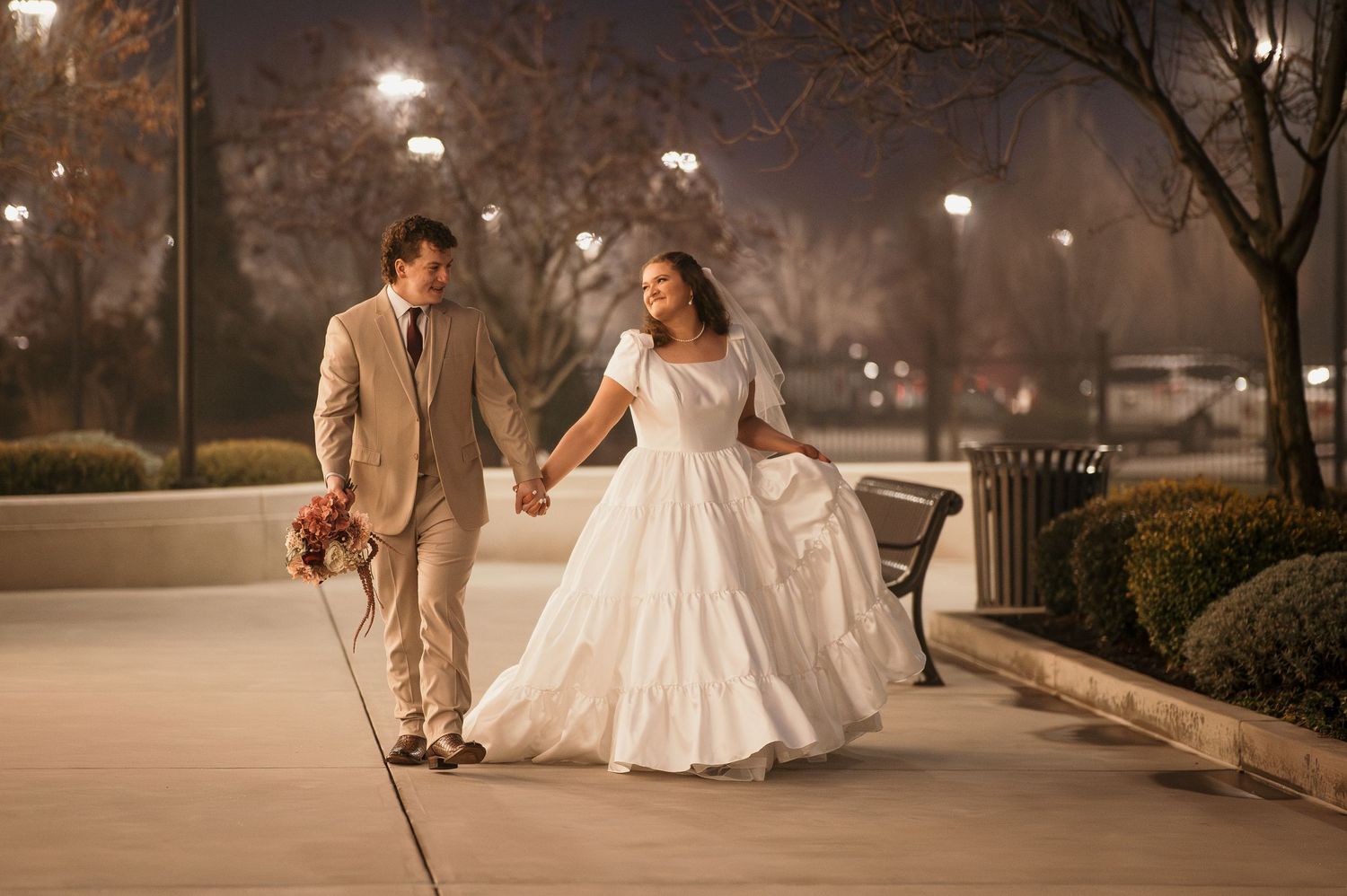 A newly married couple walking outside the LDS Meridian Idaho Temple at night