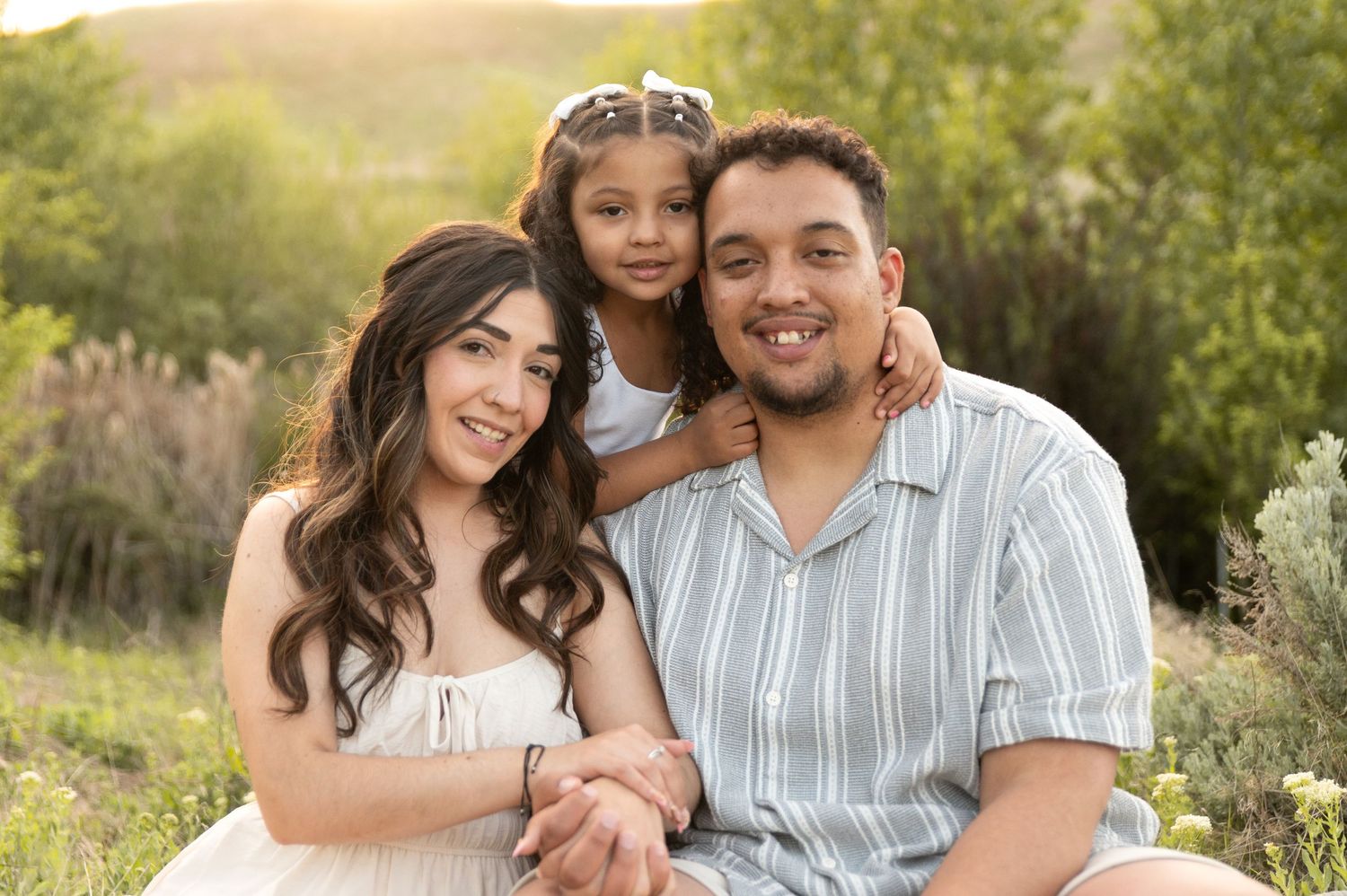 a family of 3 smiling into the camera. boise idaho