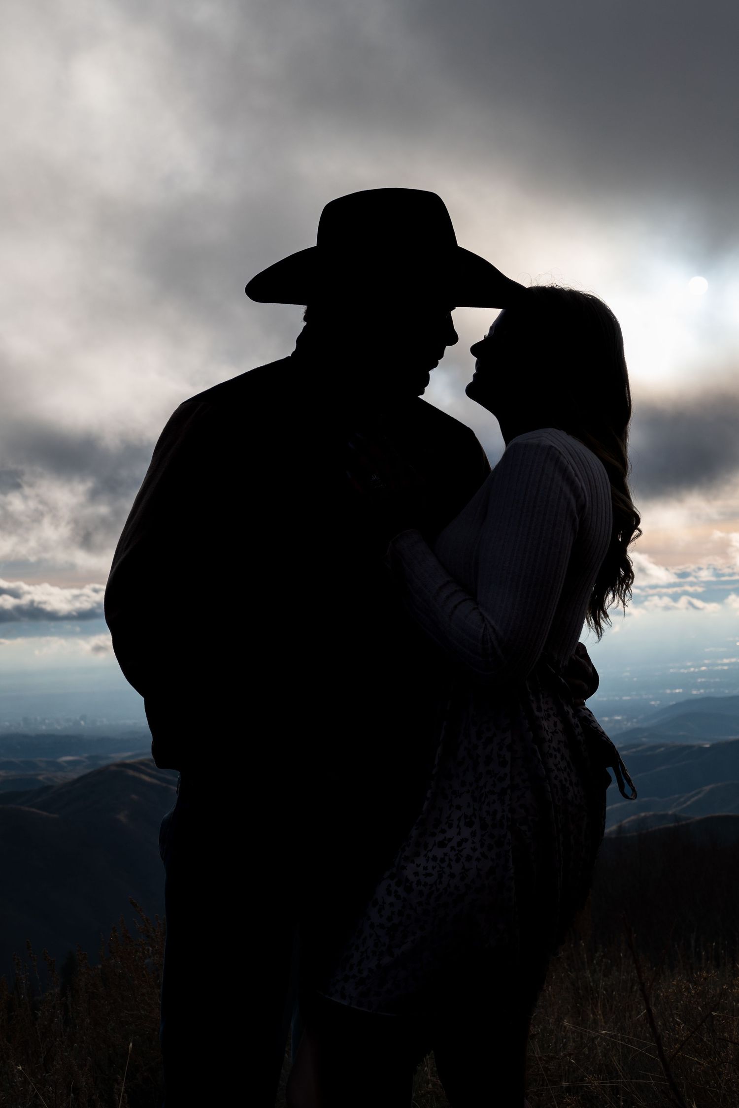 a silhouette of a western couple with a cowboy hat in front of a dramatic sunset in Boise, Idaho.