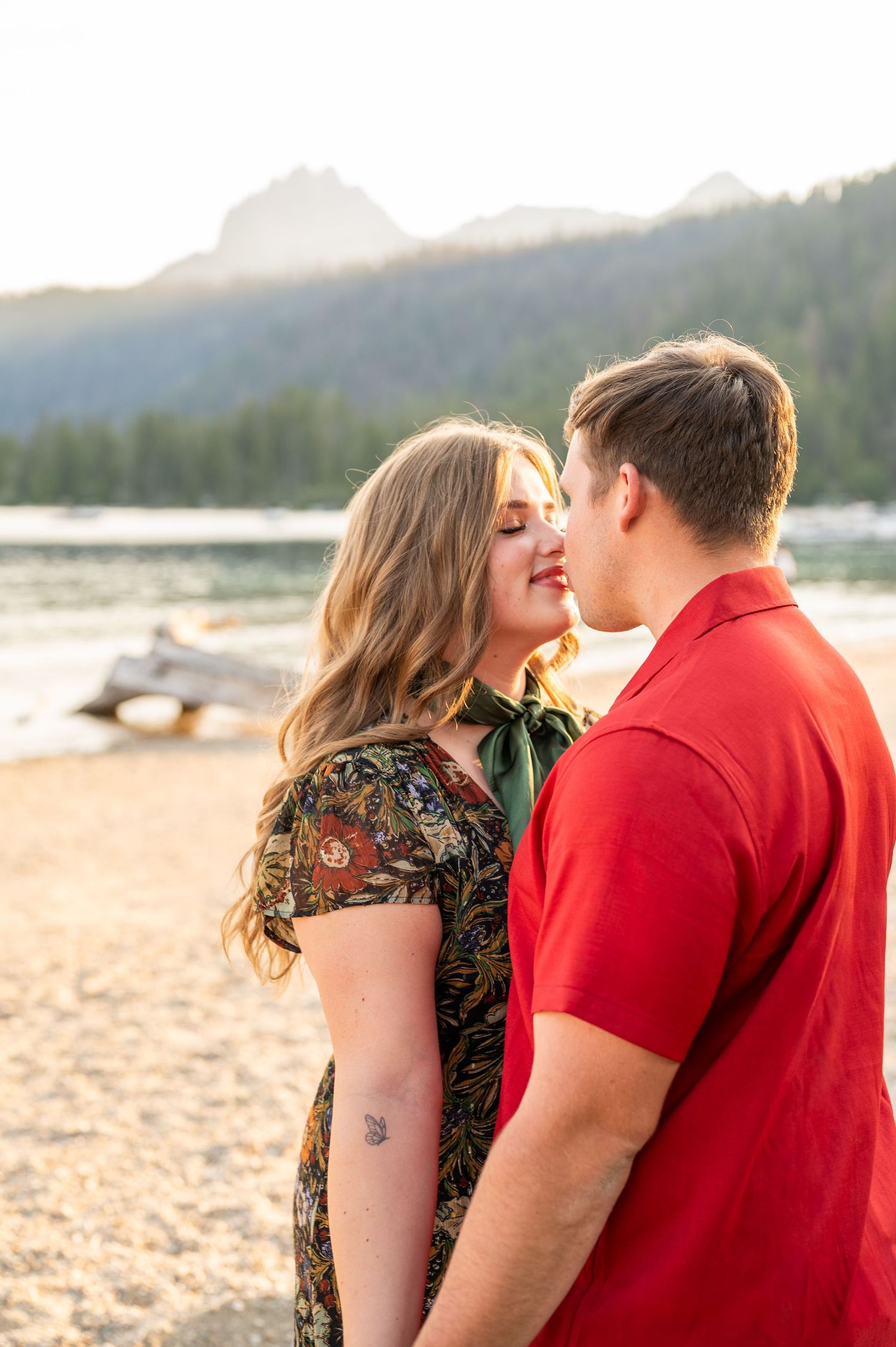 A couple kissing at Redfish lake in front of the Sawtooth mountains.