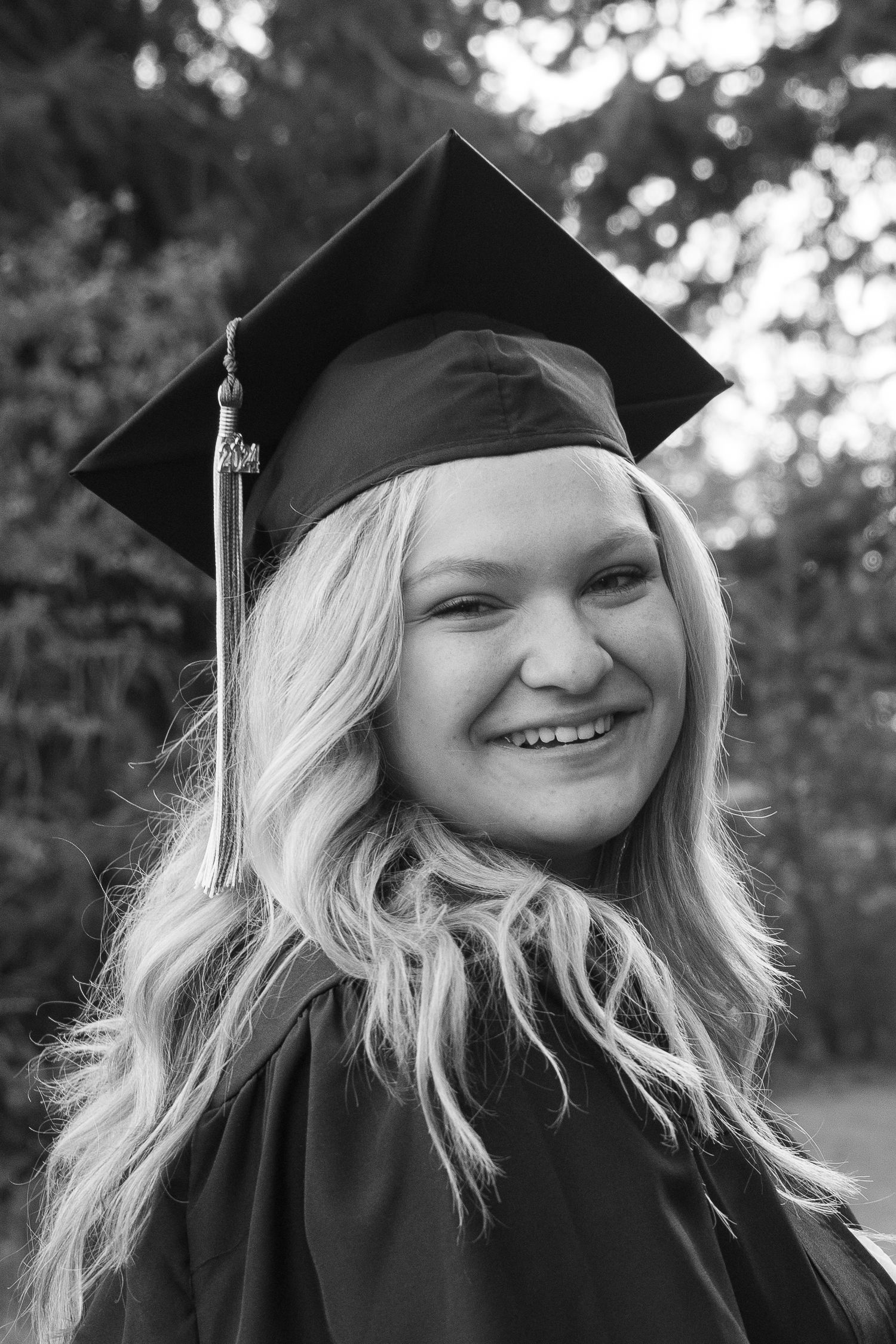 a senior posing in cap and gown in boise, idaho