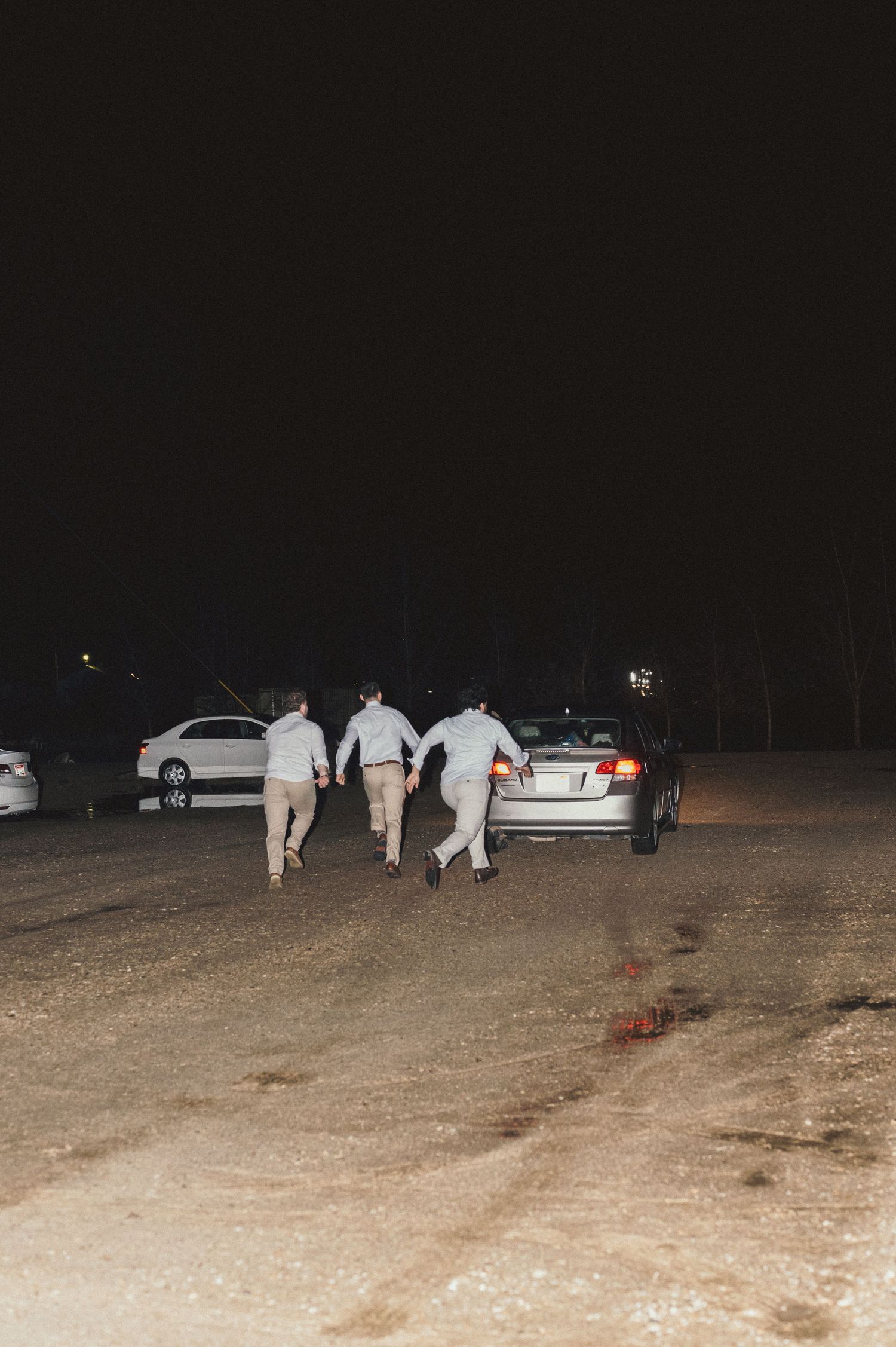 Groomsman chasing a car after a bride and groom leave in Kuna, Idaho