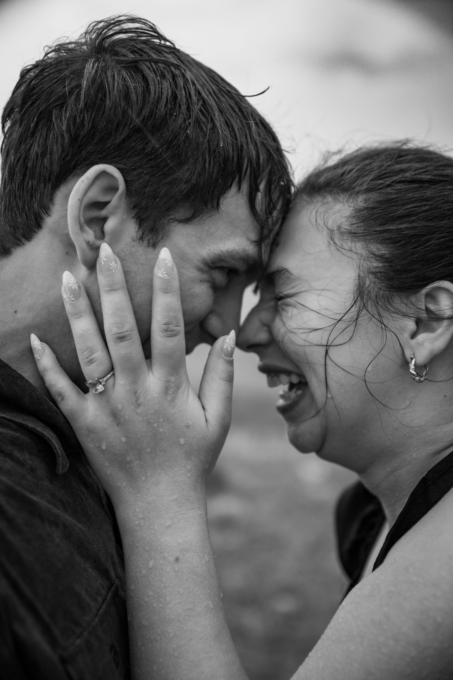 A couple laughing together during a rainy Bogus Basin photoshoot in Boise, Idaho.