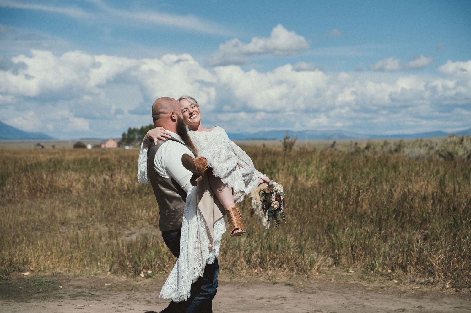 A candid moment of a groom carrying his bride after their adventurous elopement in Grand Teton National Park.