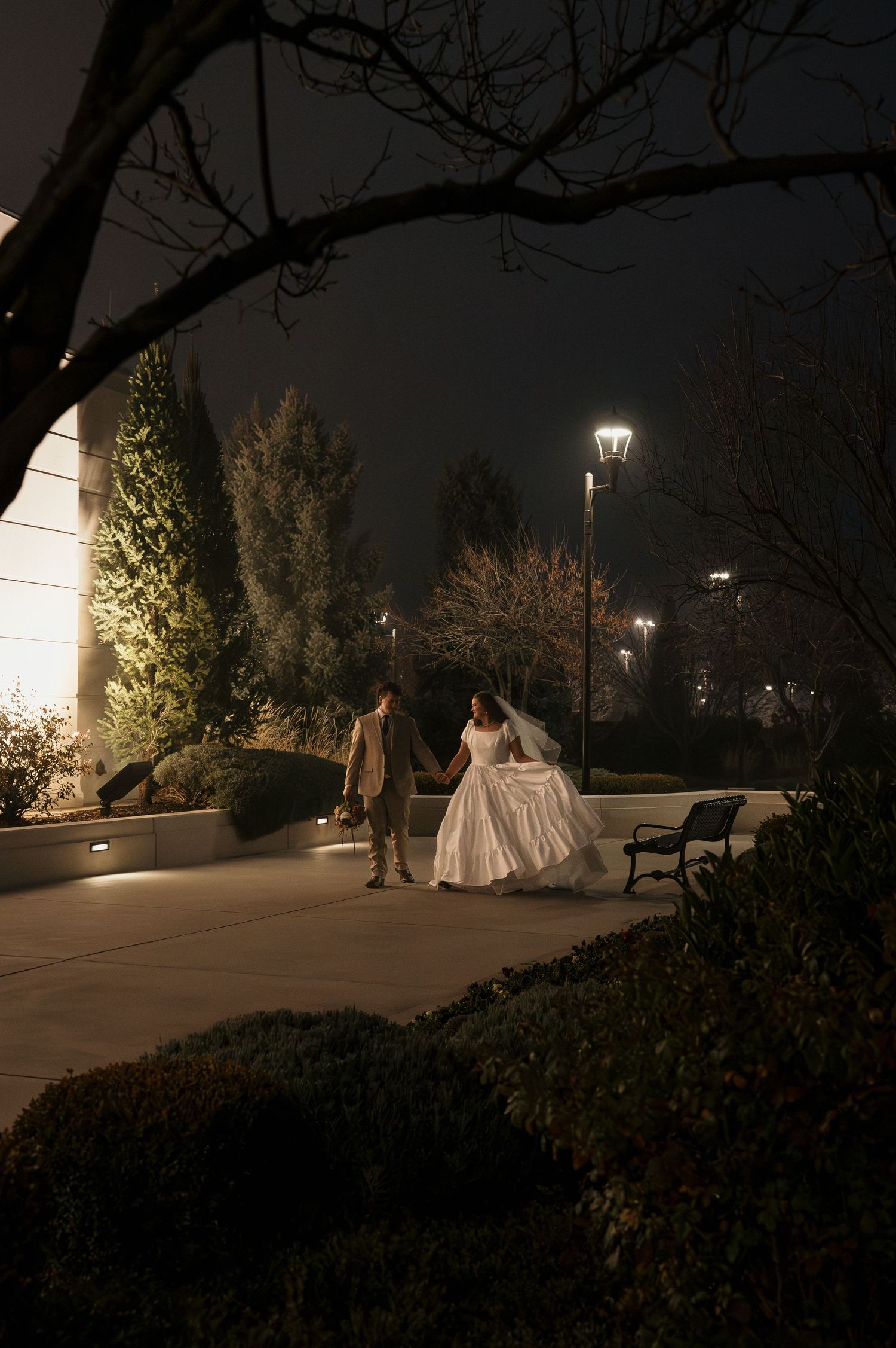 A newly married couple walking outside the LDS Meridian Idaho Temple at night