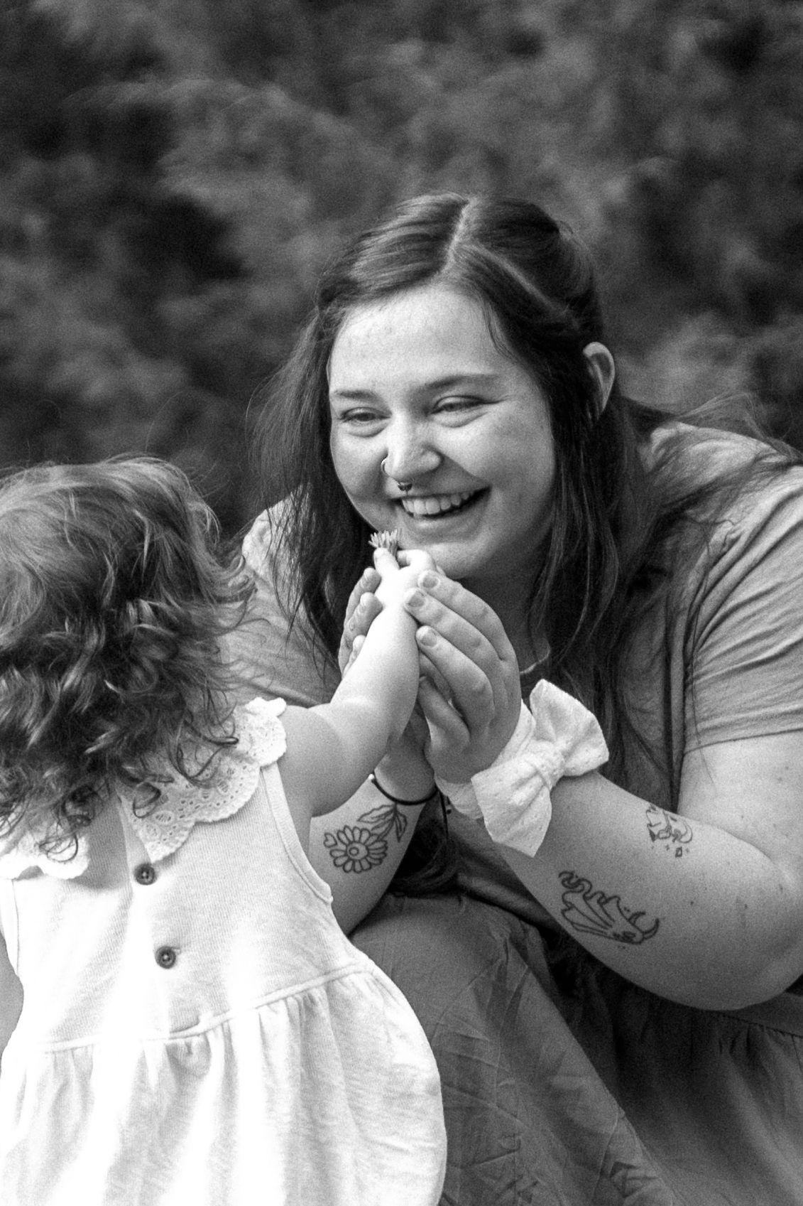 A toddler gifting her mom a flower during a family photoshoot in Kathryn Albertson Park in Boise, Idaho.