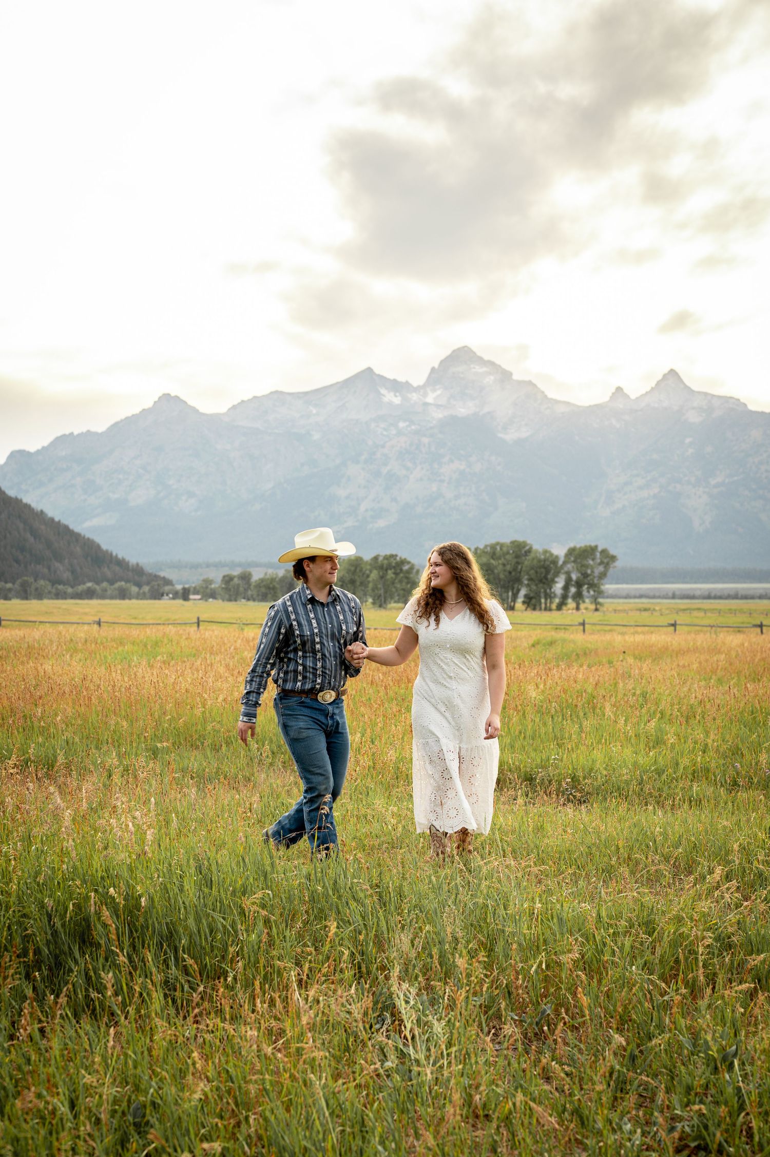 A couple walking together at Mormon Row in front of the Tetons.