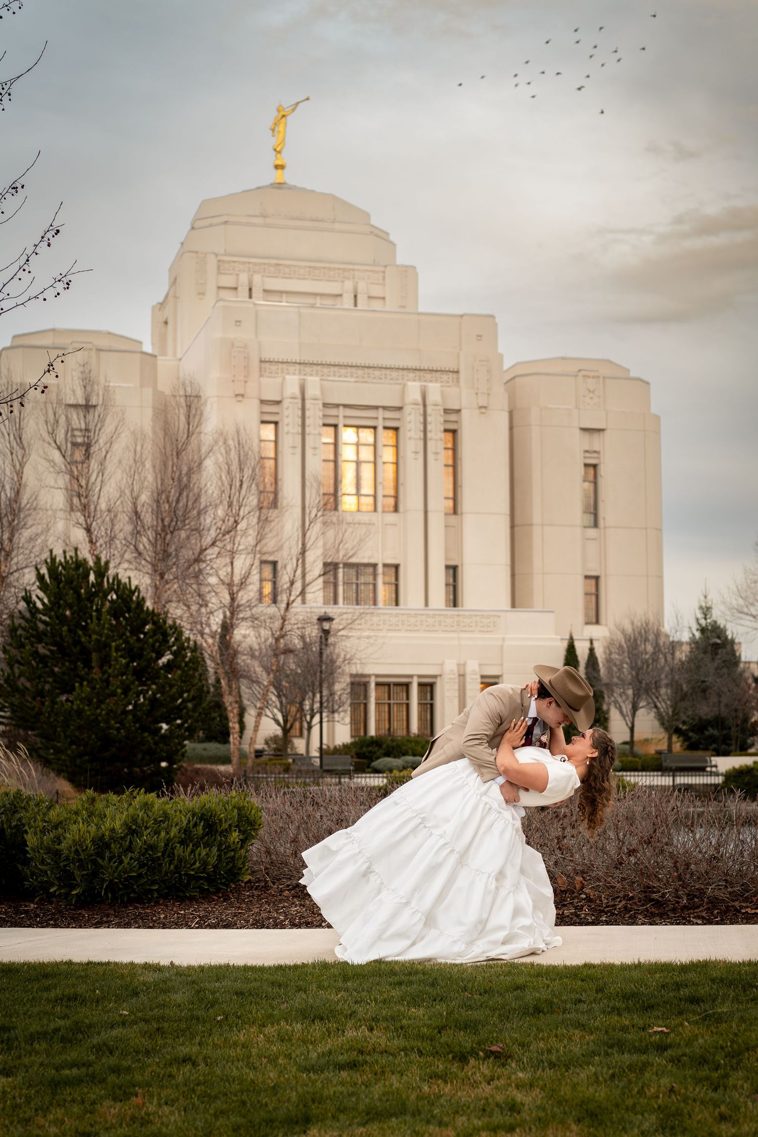 A newly married couple kissing outside the LDS Meridian Idaho Temple