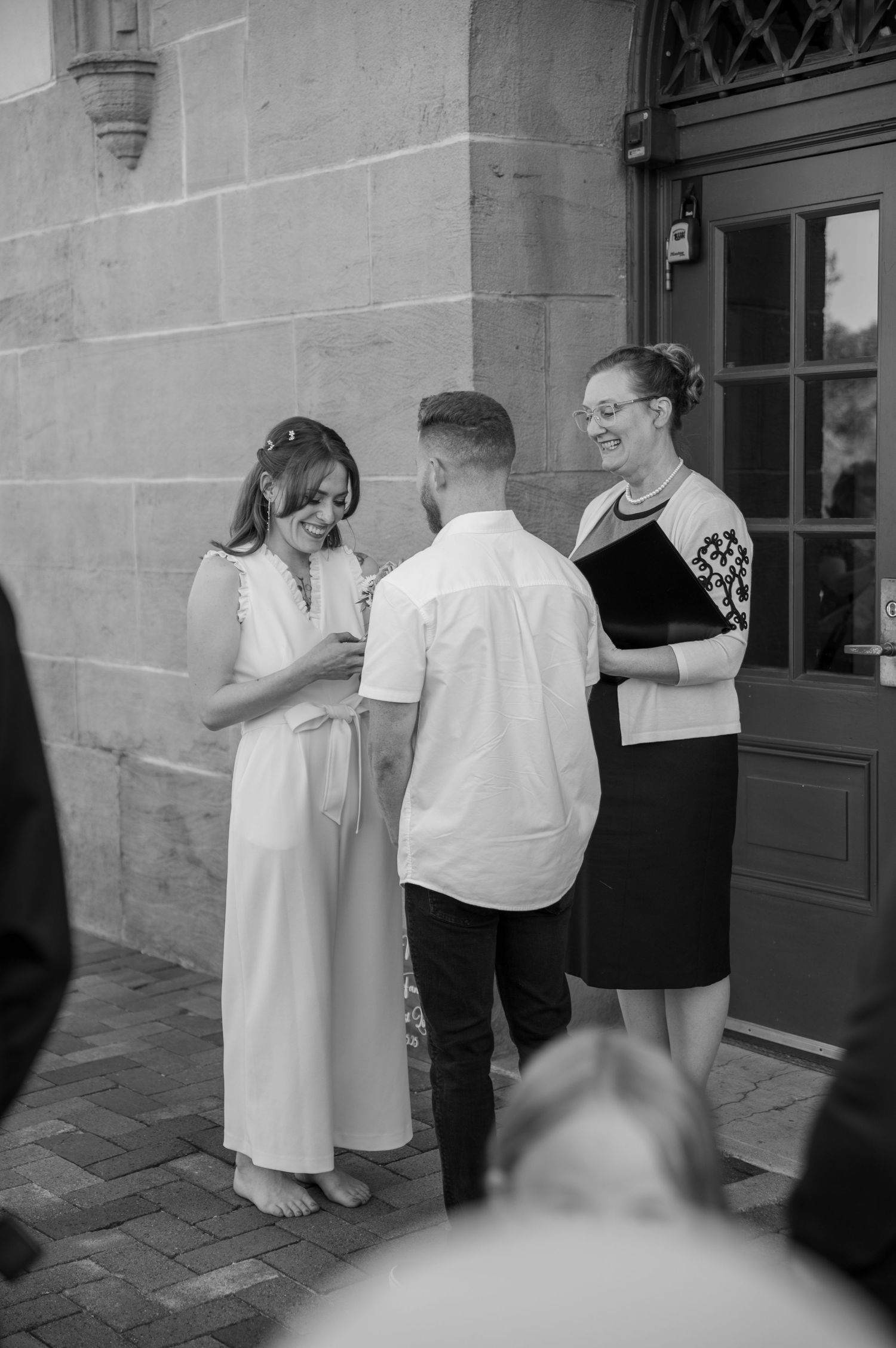 A bride laughing while reading her vows to her groom outside the Boise Train Depot in Boise, Idaho.
