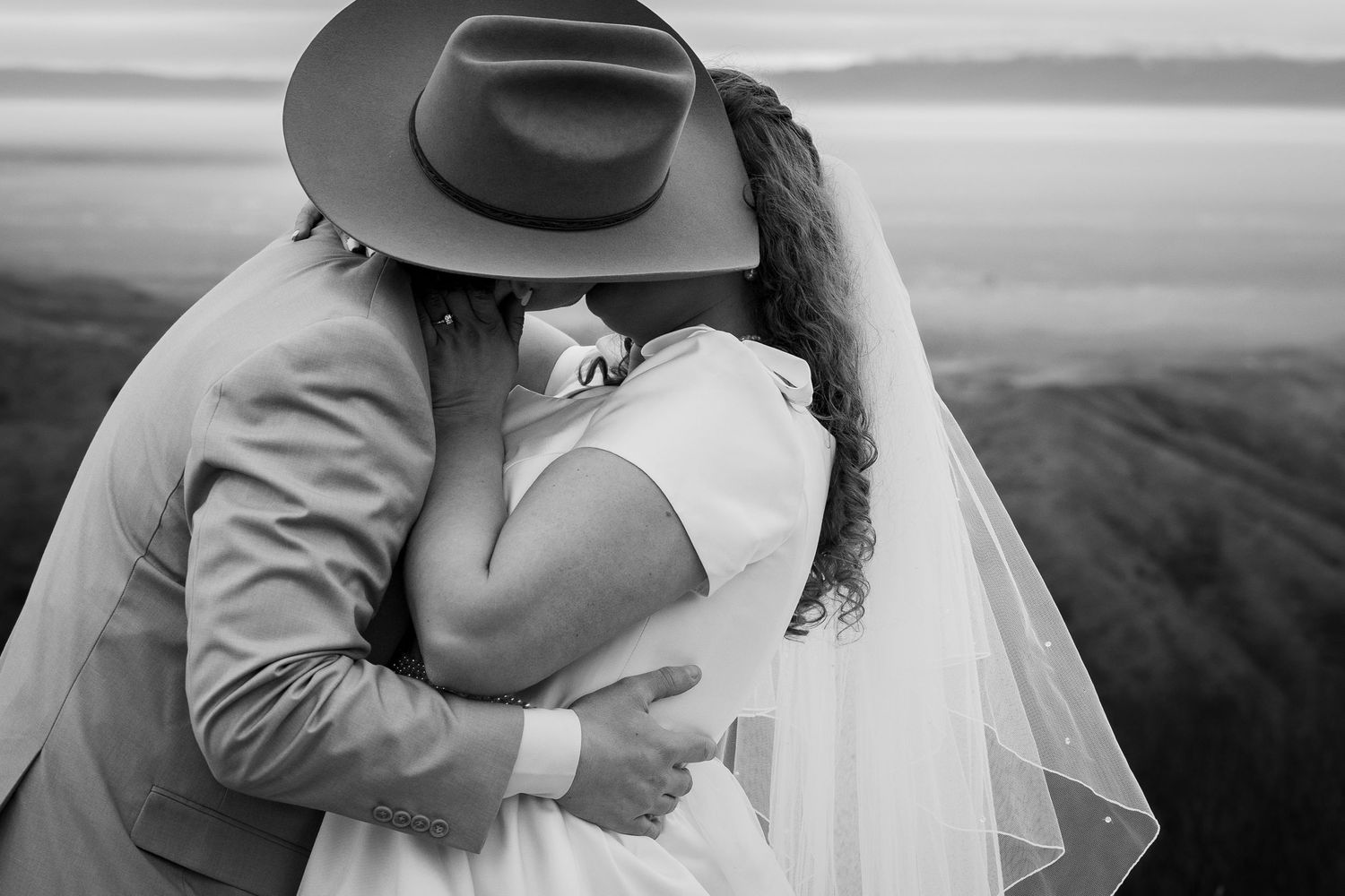 Bride and Groom sharing a kiss after their first look with crazy mountain views behind them. Boise, Idaho.