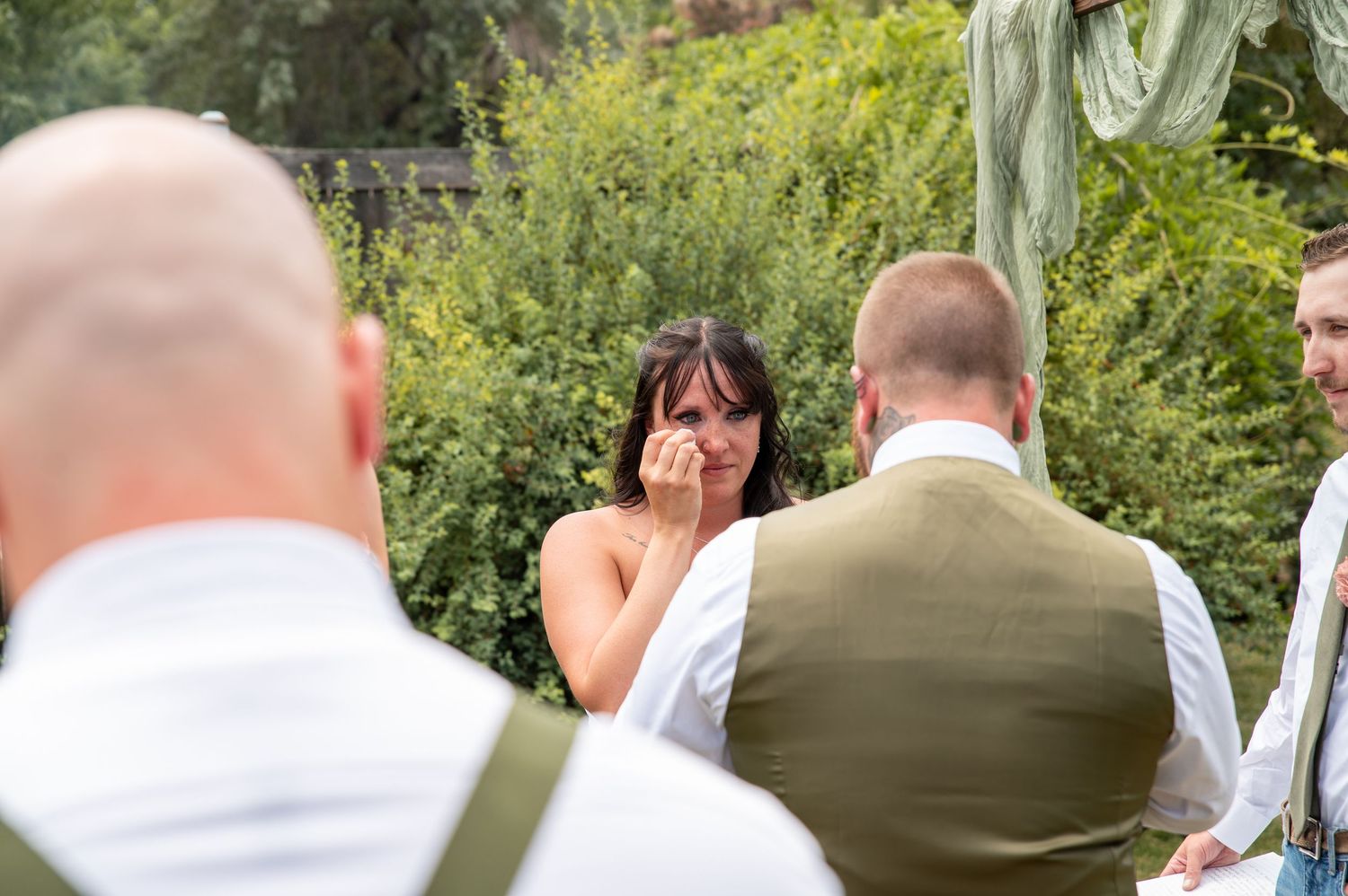 A bride wipes a tear while the groom reads her his vows at their ceremony in Boise, Idaho.