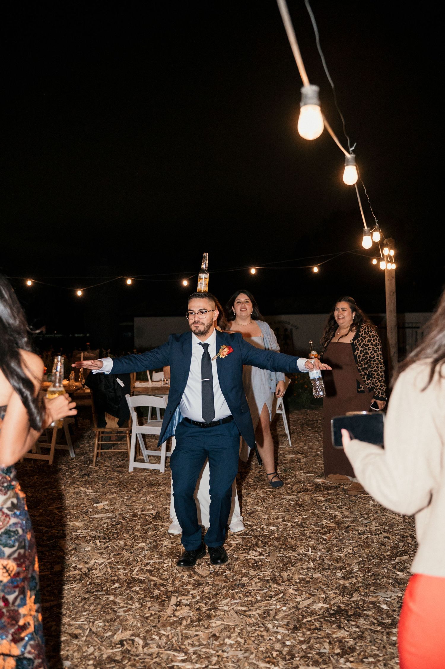 A groom dancing with a drink balanced on his head at his party in Eagle Idaho at Good Life Farms
