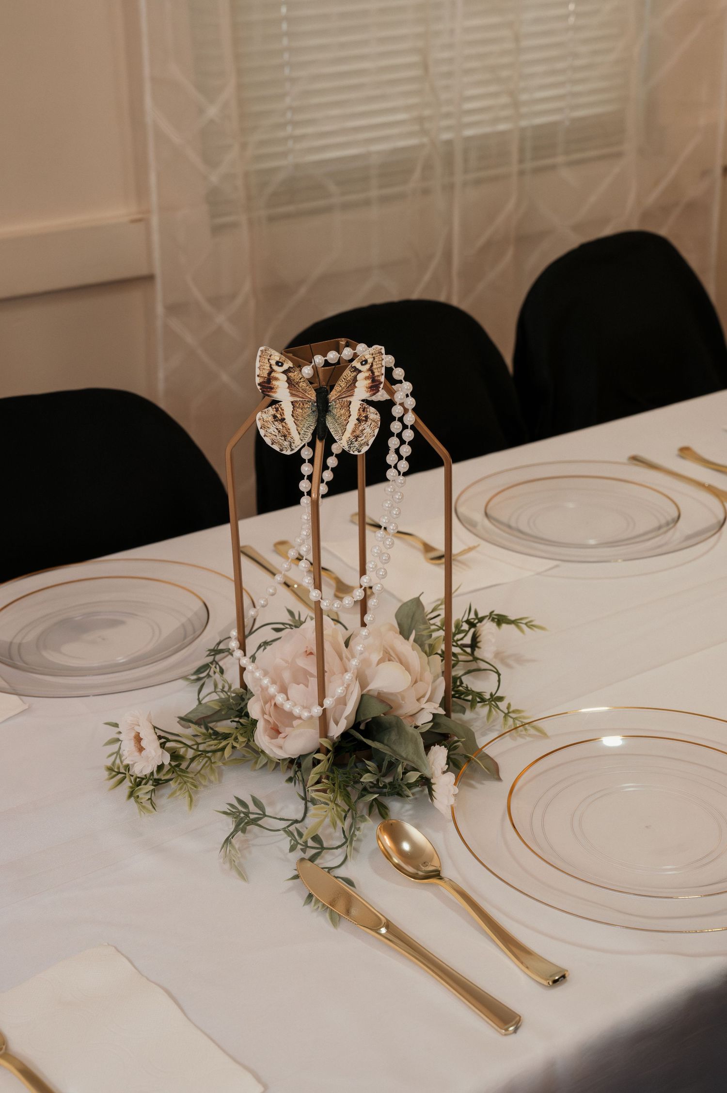 A floral centerpiece featuring pearls and butterflies at a wedding reception in Payette, Idaho.