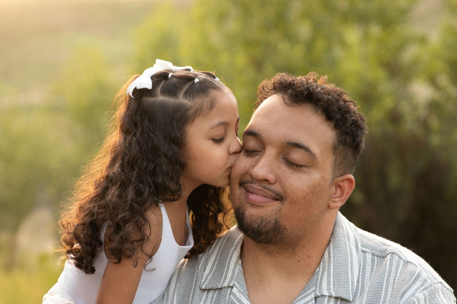 a daughter giving her dad a kiss on the cheek