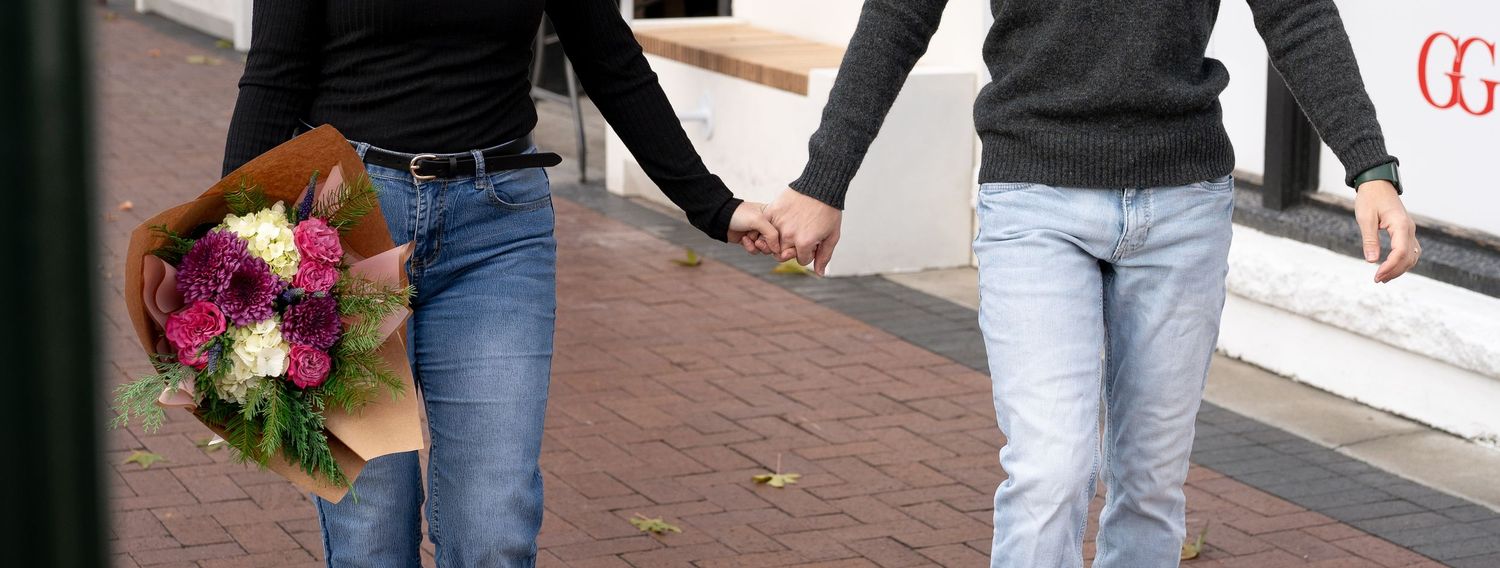 A detail shot of a couple holding hands and flowers in downtown Boise, Idaho.