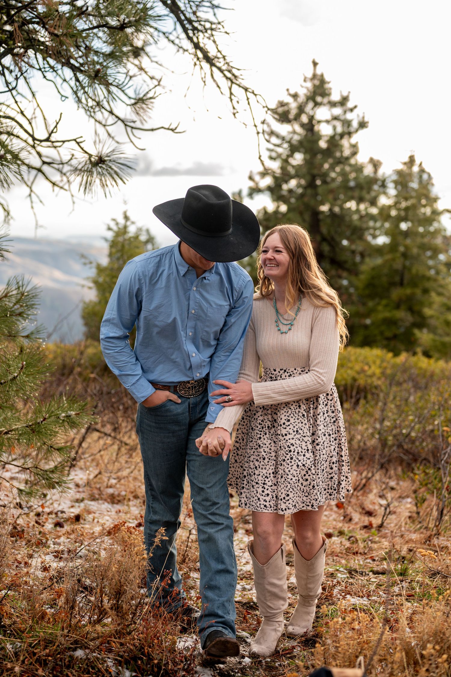 a cute country couple laughing during a mountain engagement shoot in idaho.