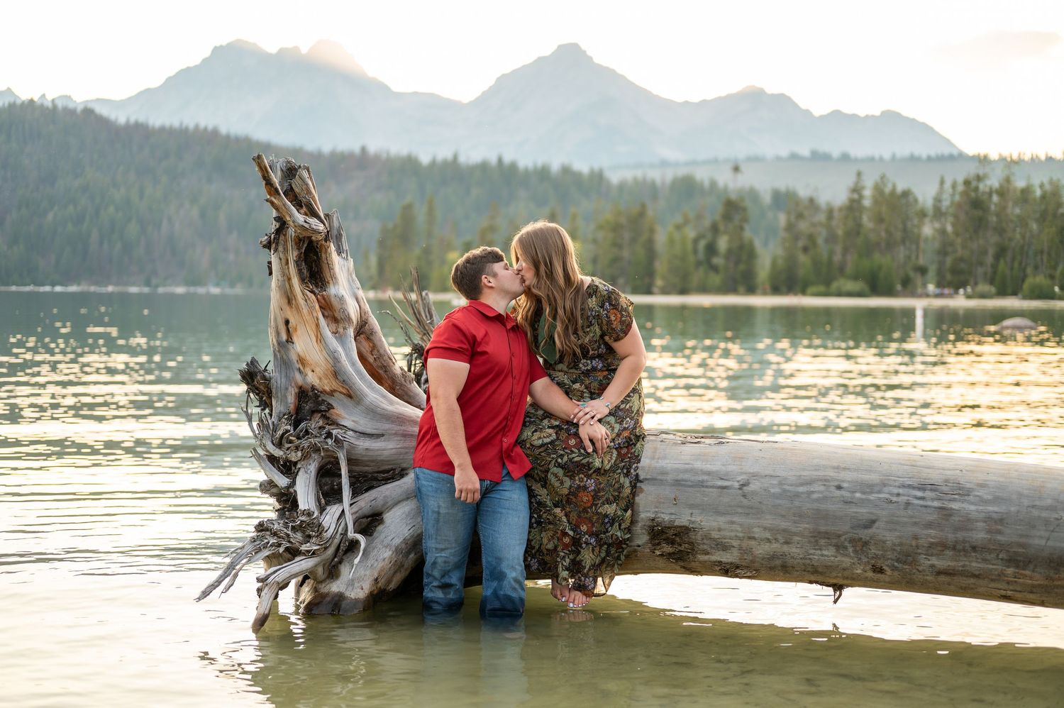 A couple sharing a kiss while in the water in front of the mountains in Stanley, Idaho.