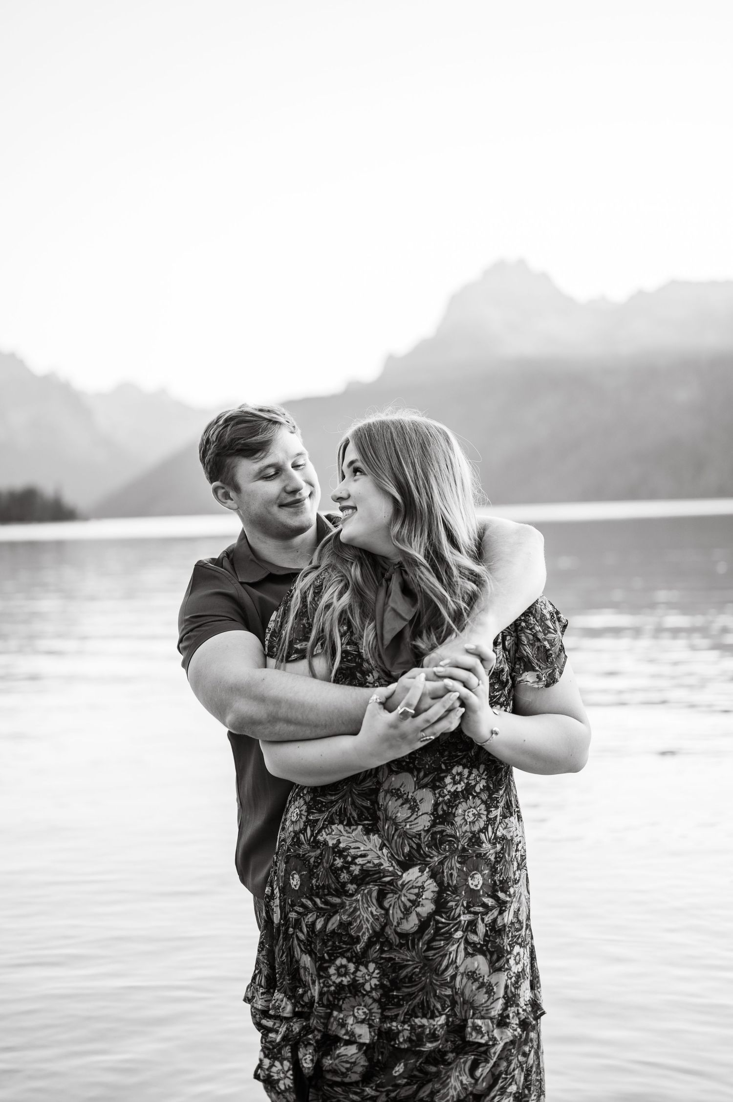 A couple looking at each other at Redfish lake in front of the Sawtooth mountains.
