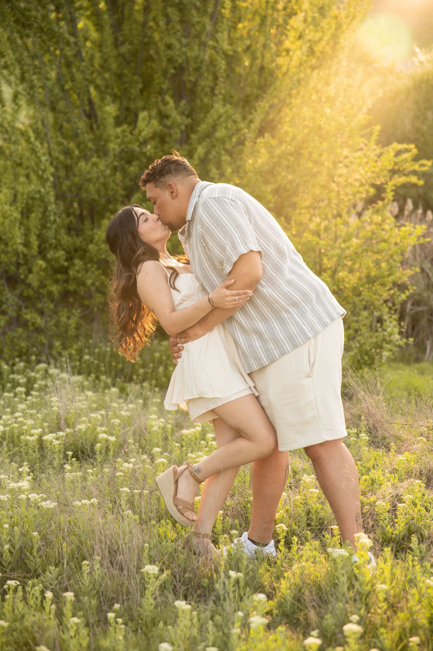 A couple shares a kiss with beautiful golden hour lighting in Boise, Idaho.